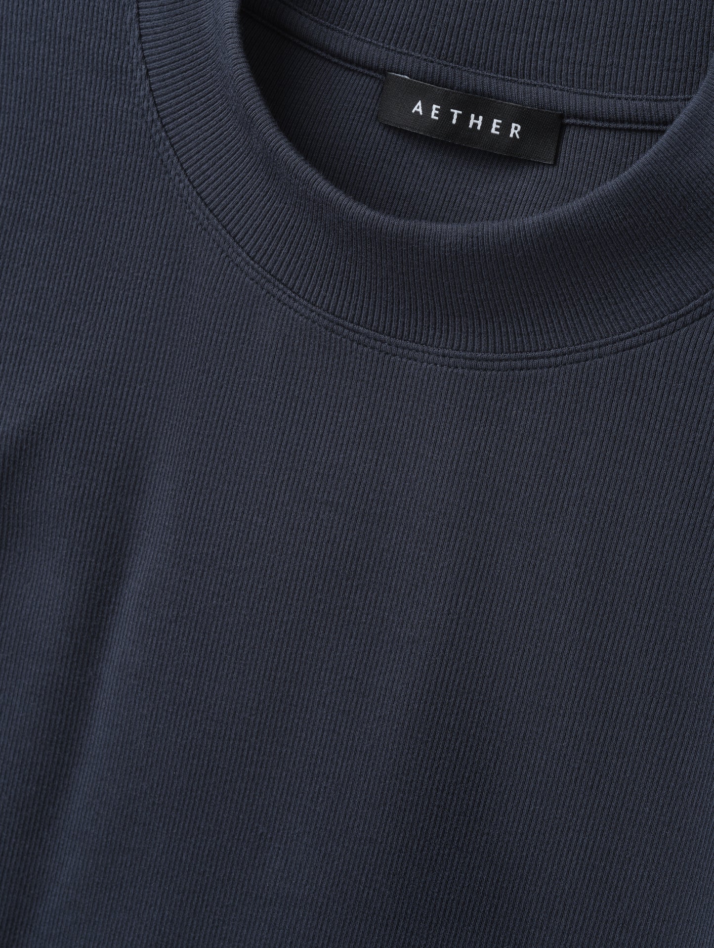 Closeup detailed view of the rib-knit fabric on the Legacy Long-Sleeve Shirt in Total Eclipse from AETHER Apparel.