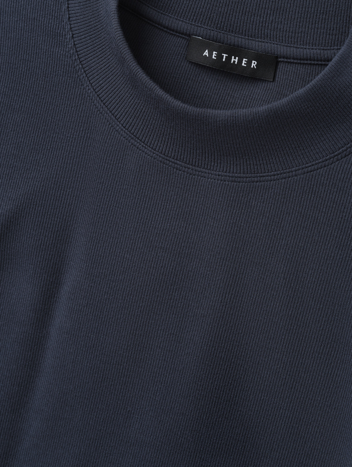 Closeup detailed view of the rib-knit fabric on the Legacy Long-Sleeve Shirt in Total Eclipse from AETHER Apparel.