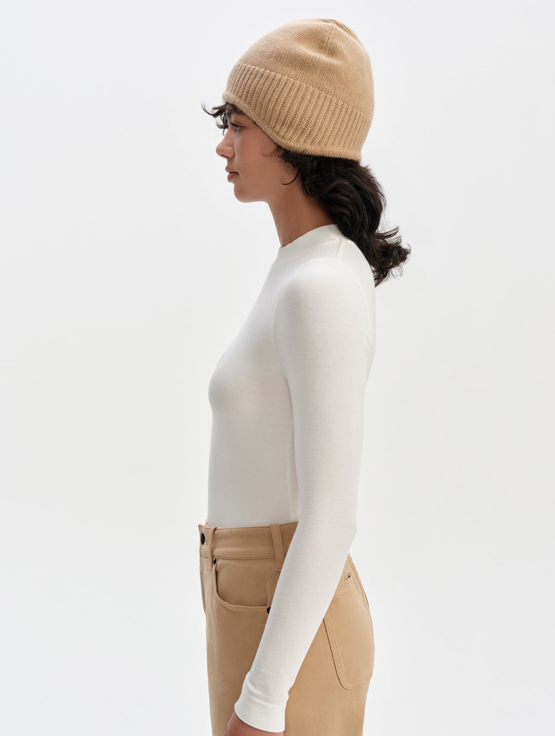 Side profile upper-body view of woman wearing the Legacy Long-Sleeve Shirt in Winter White from AETHER Apparel.