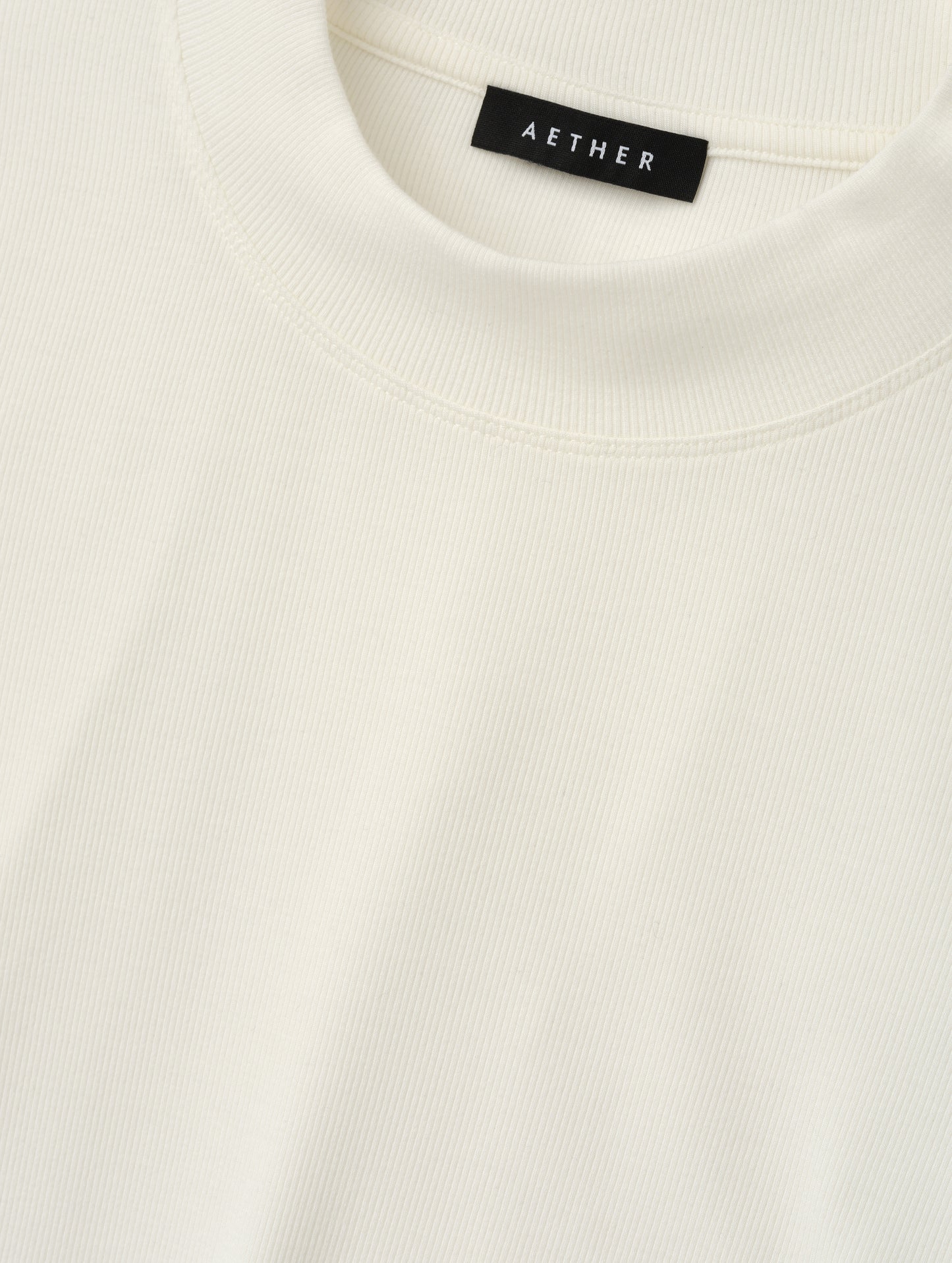 Closeup detailed view of the rib-knit fabric on the Legacy Long-Sleeve Shirt in Winter White from AETHER Apparel.