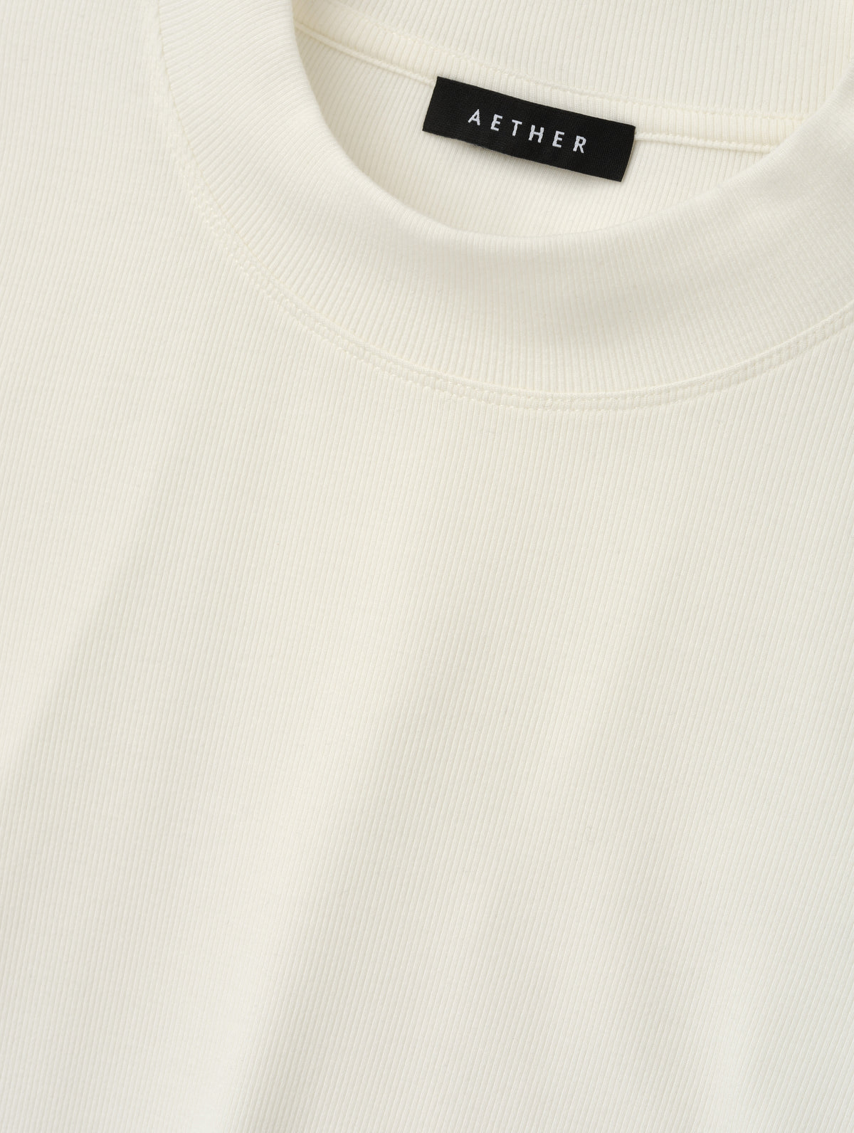 Closeup detailed view of the rib-knit fabric on the Legacy Long-Sleeve Shirt in Winter White from AETHER Apparel.