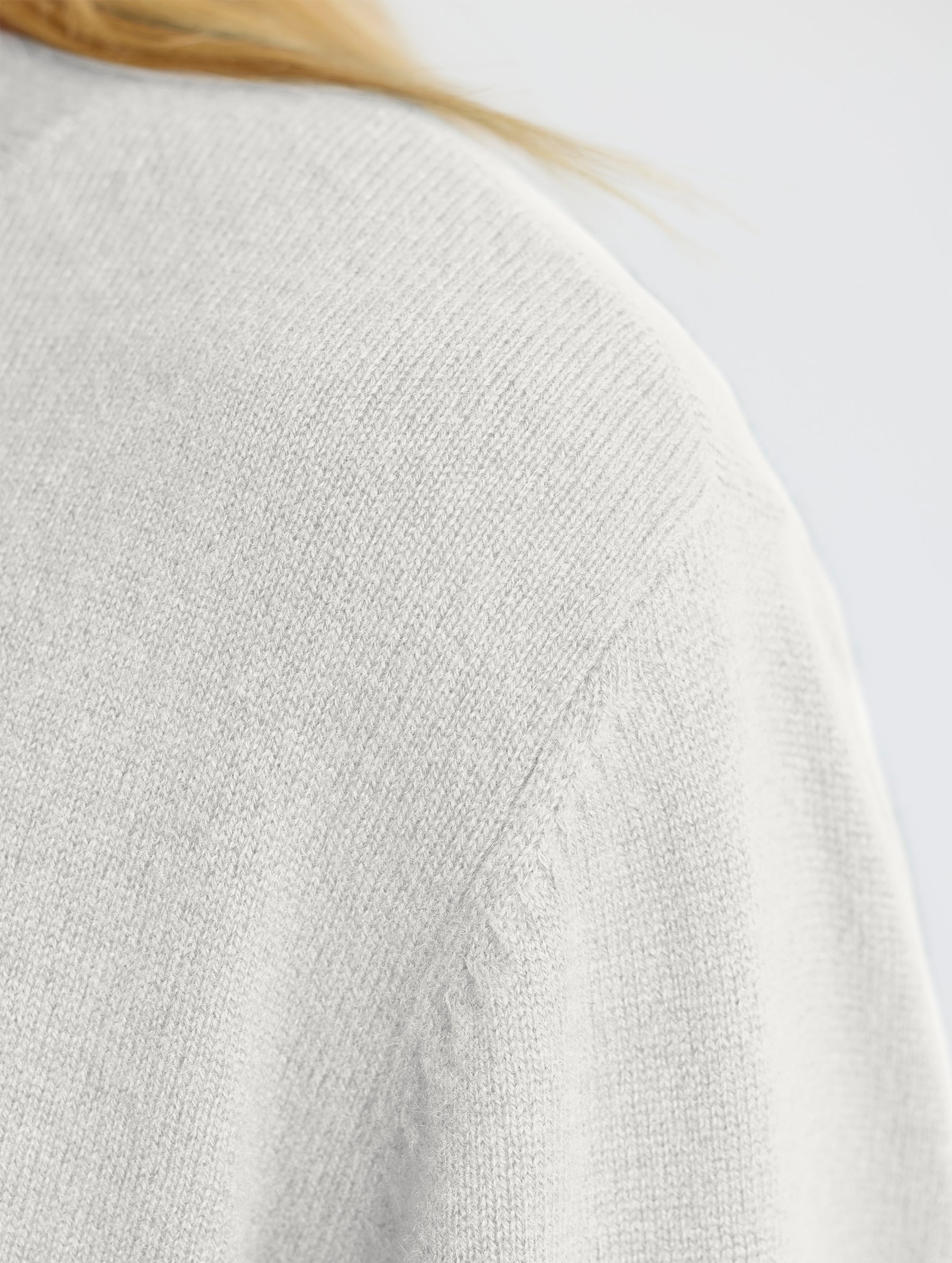 Closeup of wearer's left shoulder stitch detail view of Leigh Cashmere Crewneck in Winter White from AETHER Apparel.