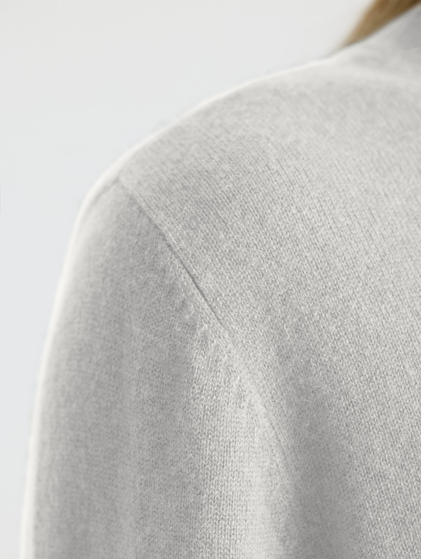 Closeup of wearer's right shoulder stitch detail view of Leigh Cashmere Crewneck in Winter White from AETHER Apparel.