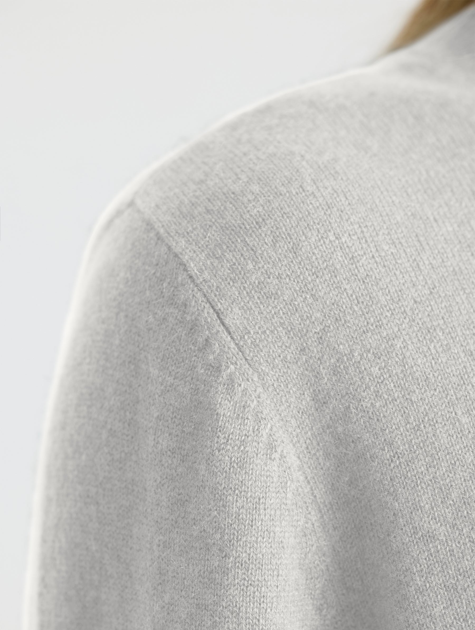 Closeup of wearer's right shoulder stitch detail view of Leigh Cashmere Crewneck in Winter White from AETHER Apparel.