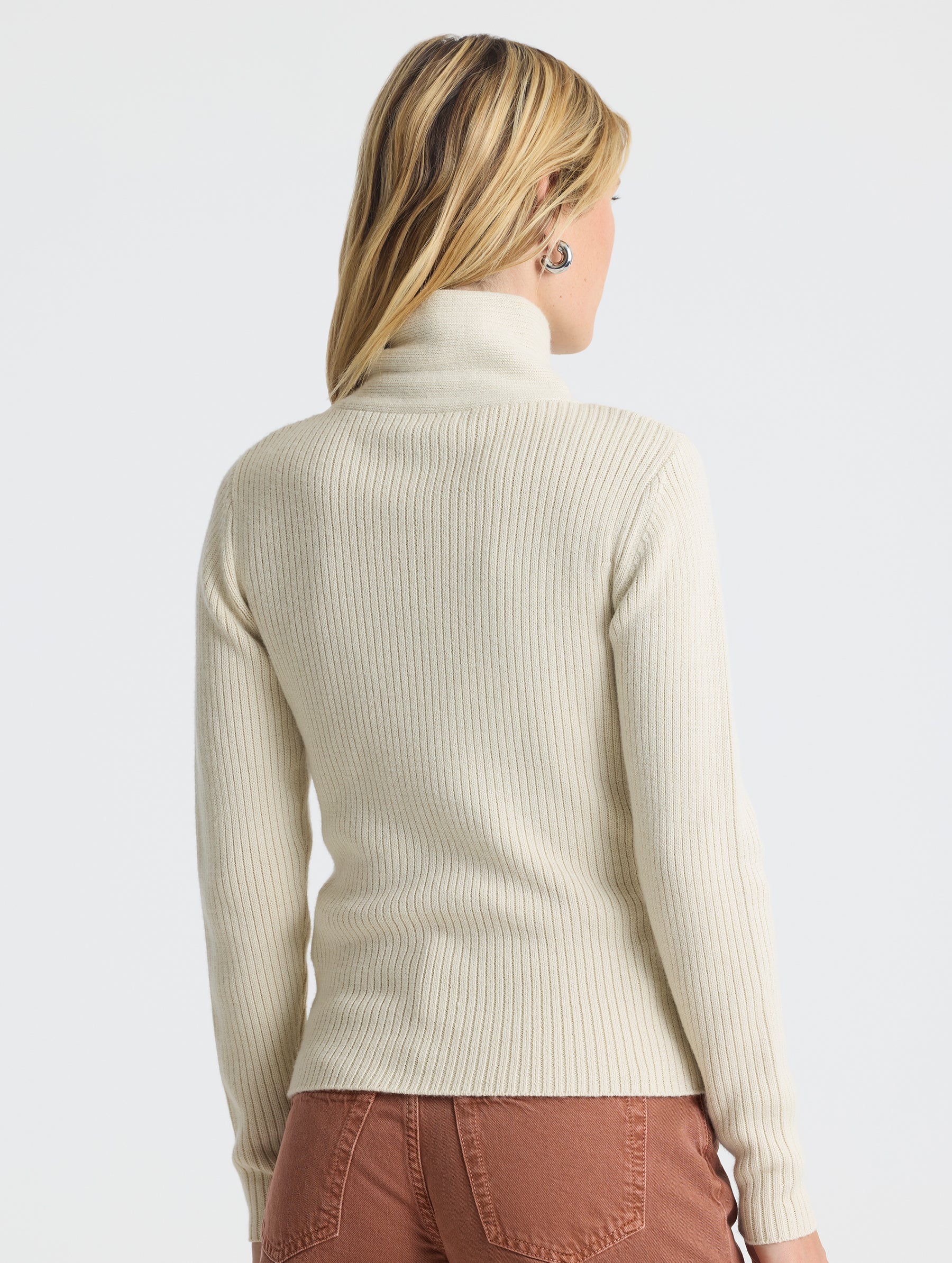 Angled rear view of woman wearing Lexington Sweater in Bone white from AETHER Apparel.