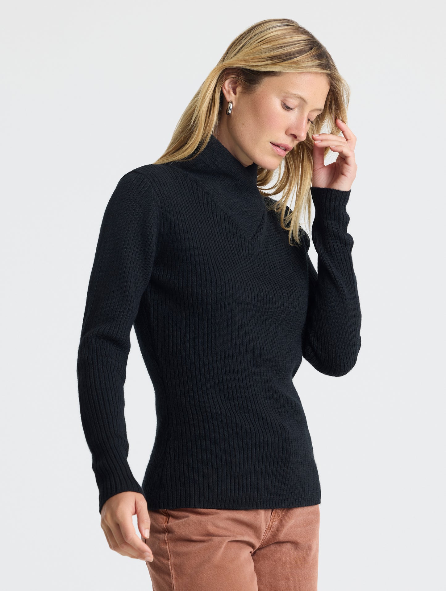 Angled view of woman wearing Lexington Sweater in Onyx Black from AETHER Apparel.