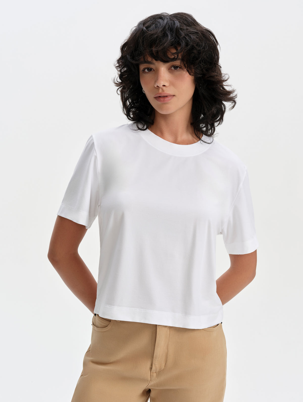 Front upper-body view of woman wearing the Lola Relaxed Tee in White from AETHER Apparel.