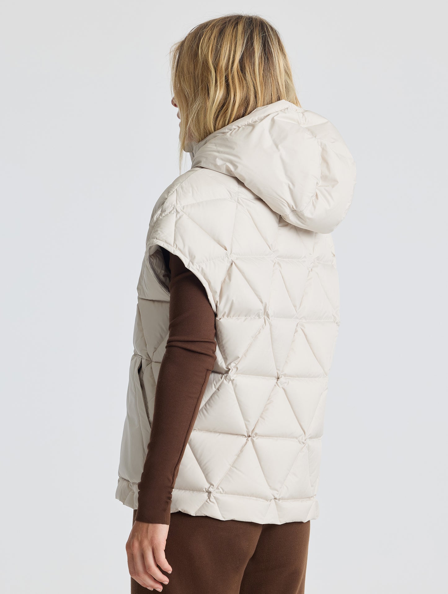 Rear 3/4 view of woman wearing Mailen Oversized Vest in Bone White from AETHER Apparel.