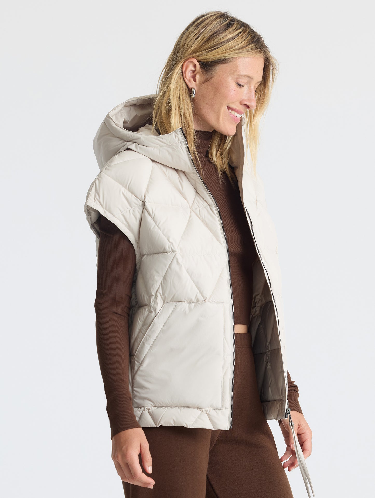 Upper body 3/4 view of woman wearing unzipped Mailen Oversized Vest in Bone White from AETHER Apparel.