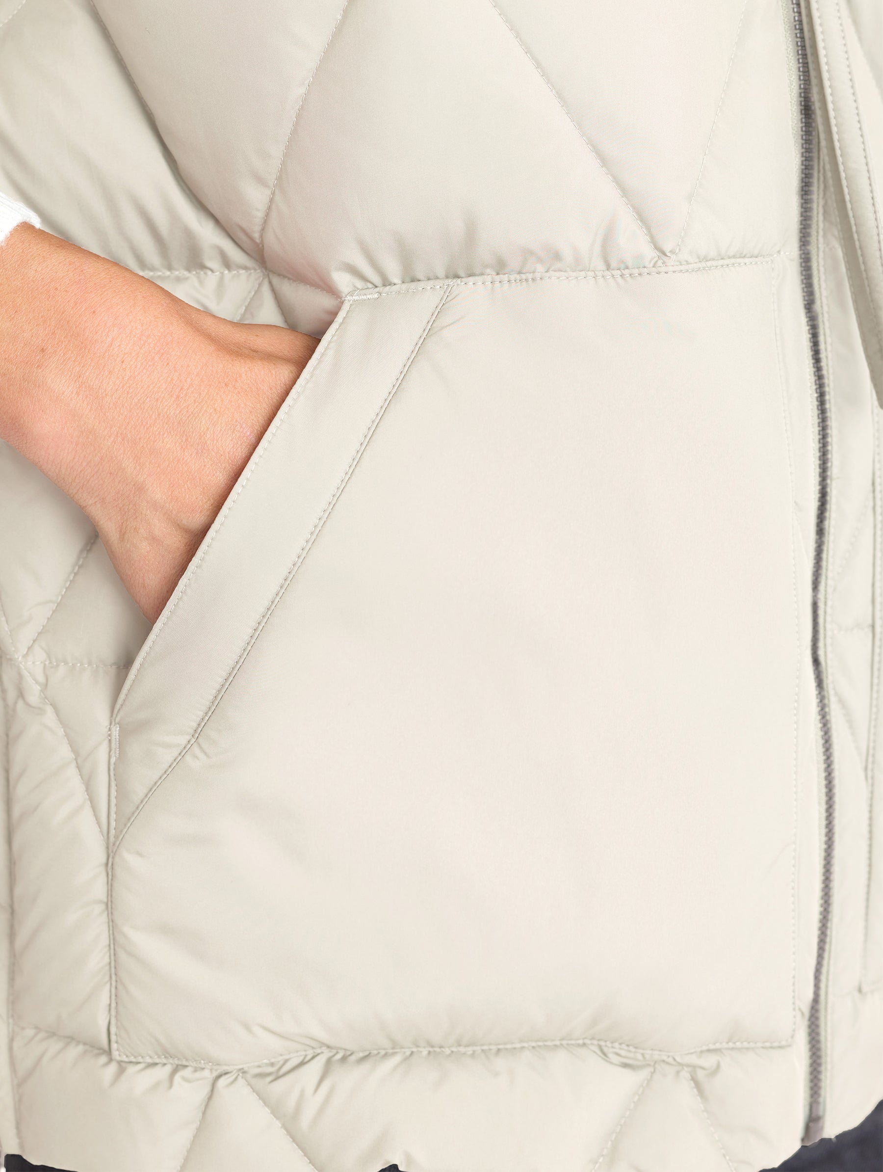 Closeup view of wearer's right pocket of Mailen Oversized Vest in Bone White from AETHER Apparel.