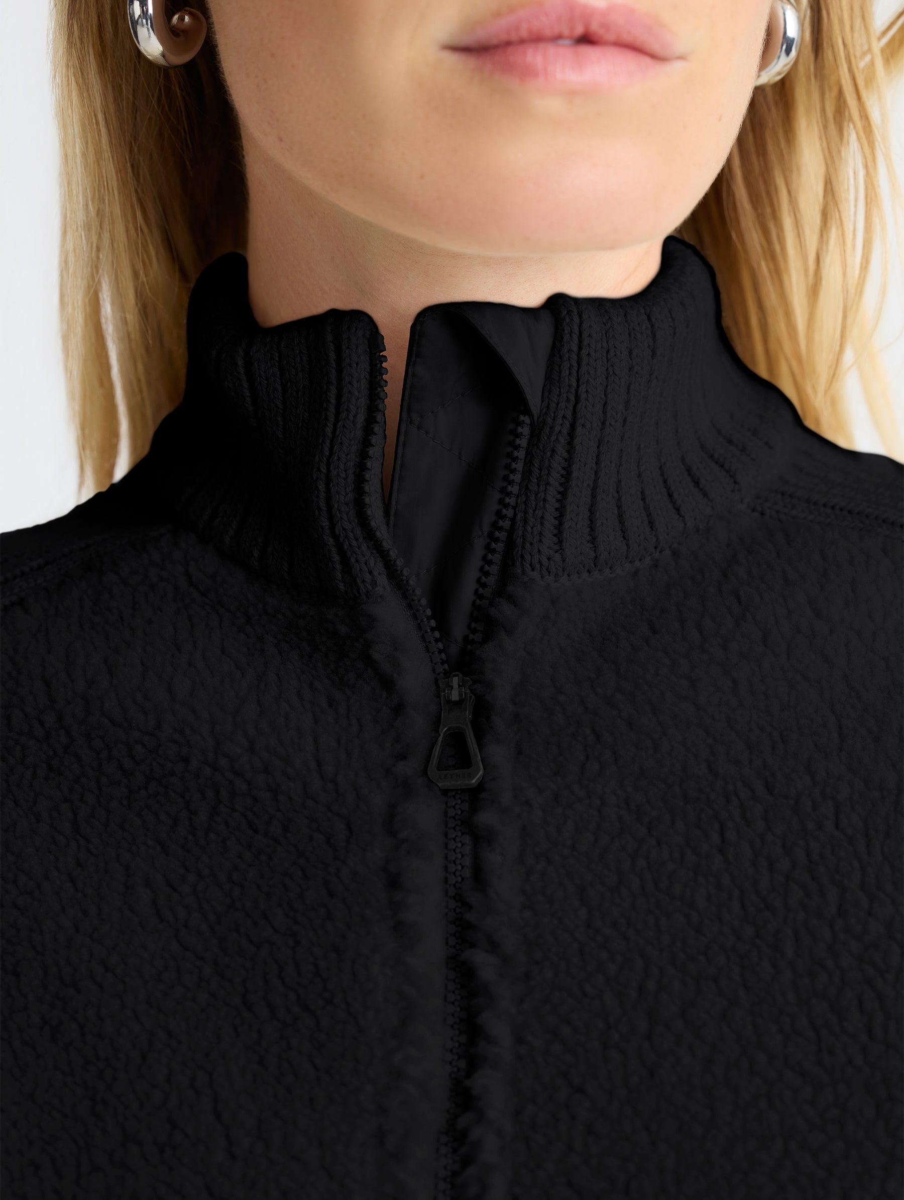 Closeup view of collar of Malina Half-Zip Sweater in Onyx Black from AETHER Apparel.