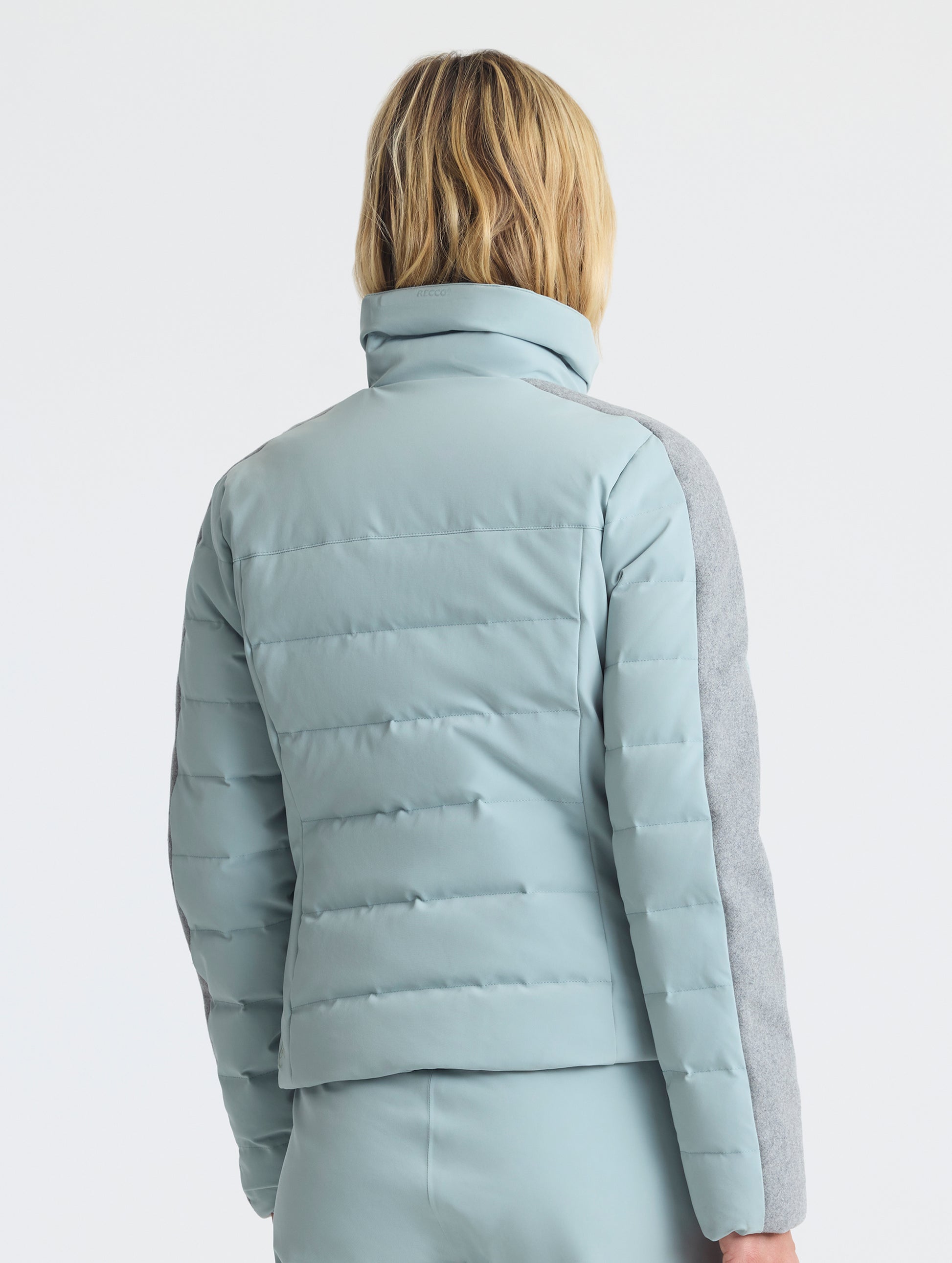 Rear angled upper-body view of woman wearing the Nordic Jacket 2.0 in Jadewood Green from AETHER Apparel.