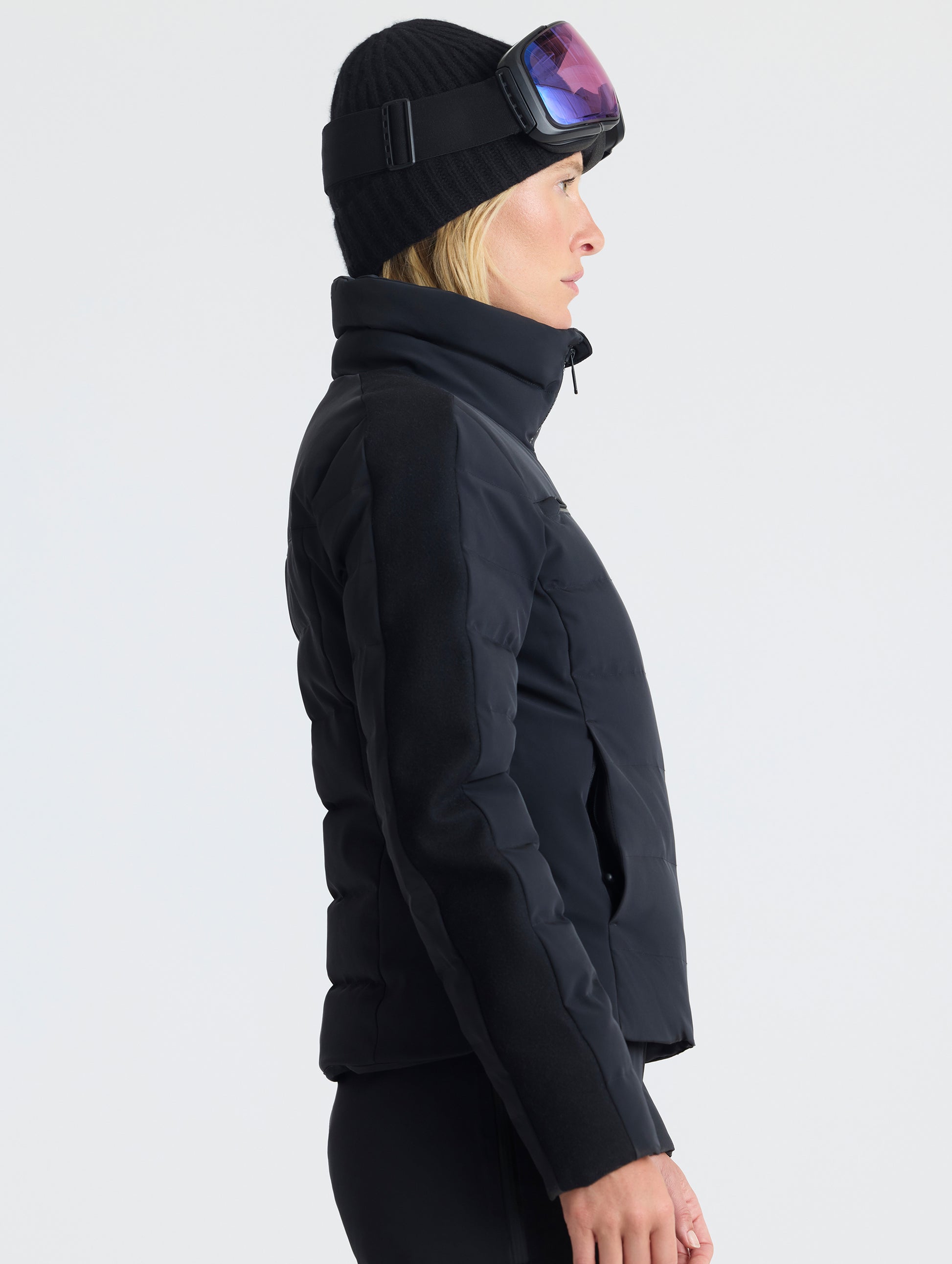 Side profile upper-body view of woman wearing the Nordic Jacket 2.0 in Onyx Black from AETHER Apparel.