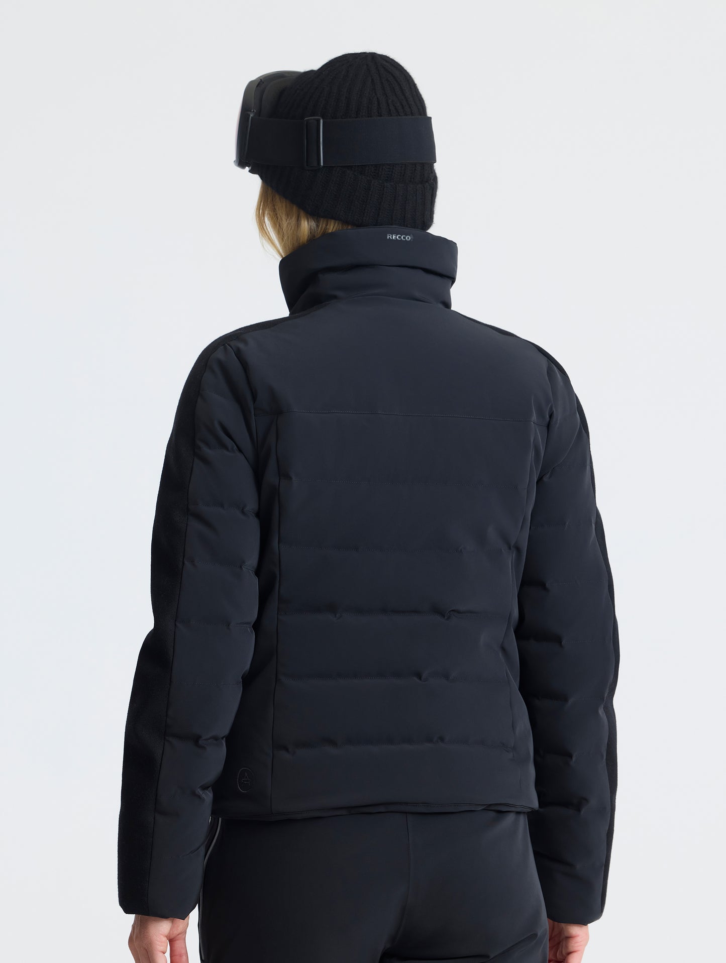 Rear angled upper-body view of woman wearing the Nordic Jacket 2.0 in Onyx Black from AETHER Apparel.