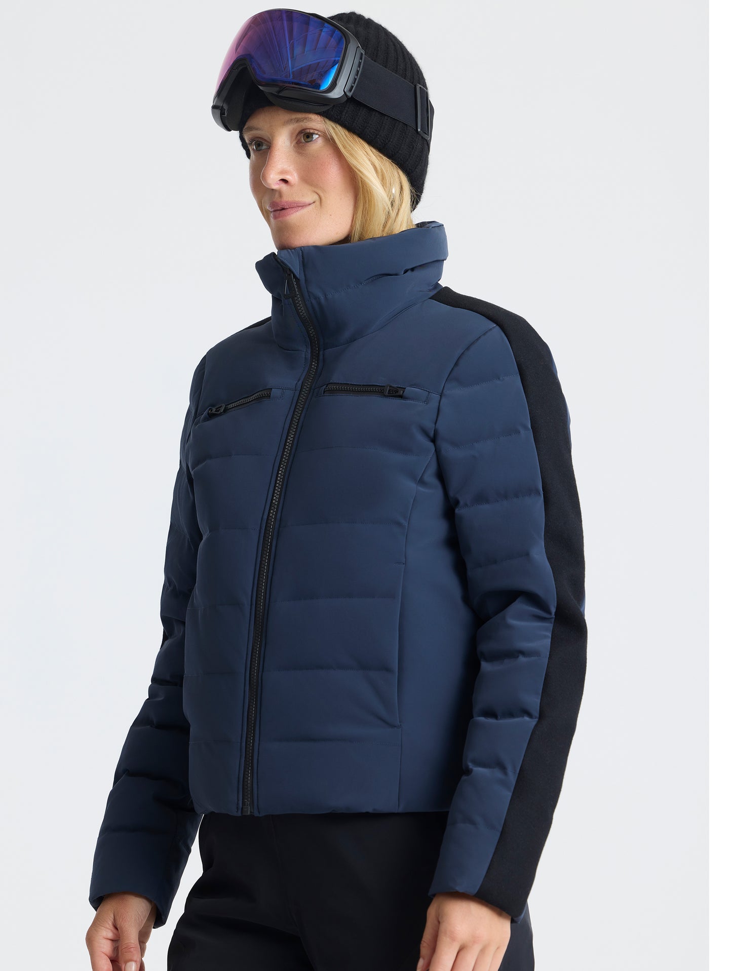 Front angled upper-body view of woman wearing the Nordic Jacket 2.0 in Total Eclipse dark blue from AETHER Apparel.