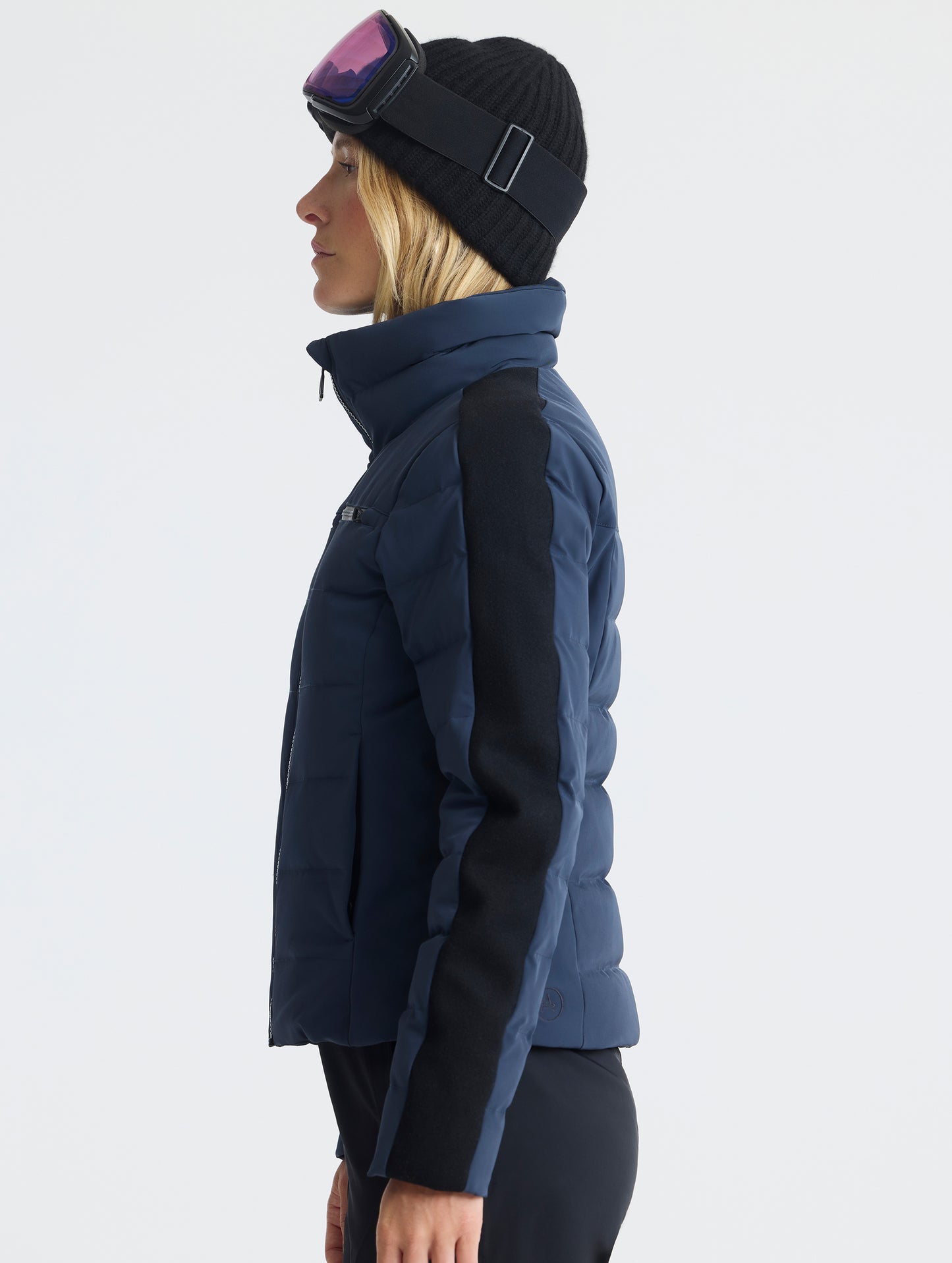 Side profile upper-body view of woman wearing the Nordic Jacket 2.0 in Total Eclipse dark blue from AETHER Apparel.