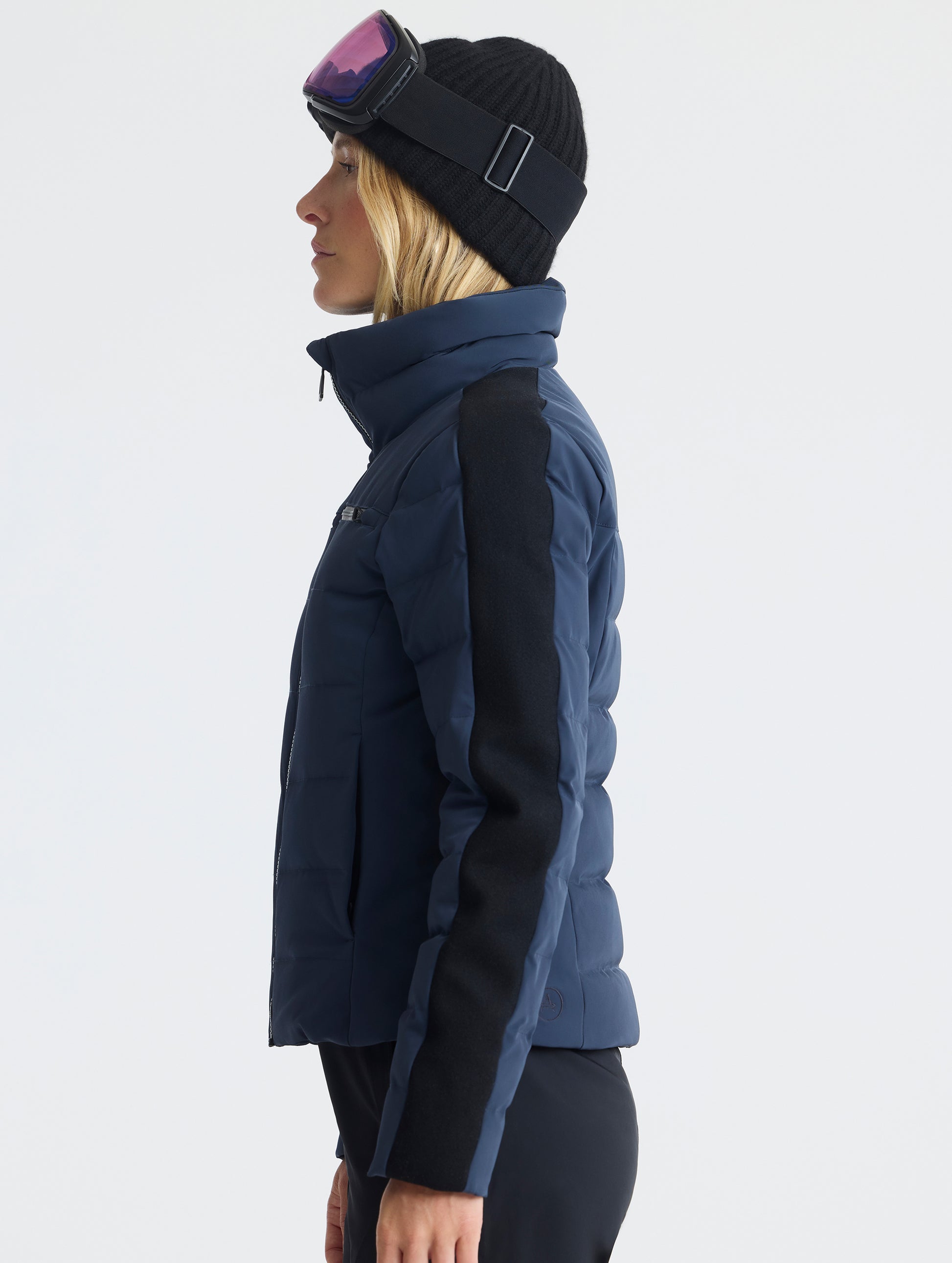 Side profile upper-body view of woman wearing the Nordic Jacket 2.0 in Total Eclipse dark blue from AETHER Apparel.