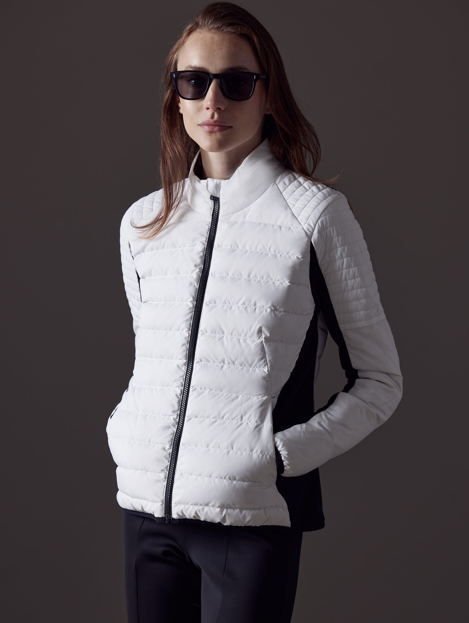 Woman wearing white quilted snow jacket from AETHER Apparel