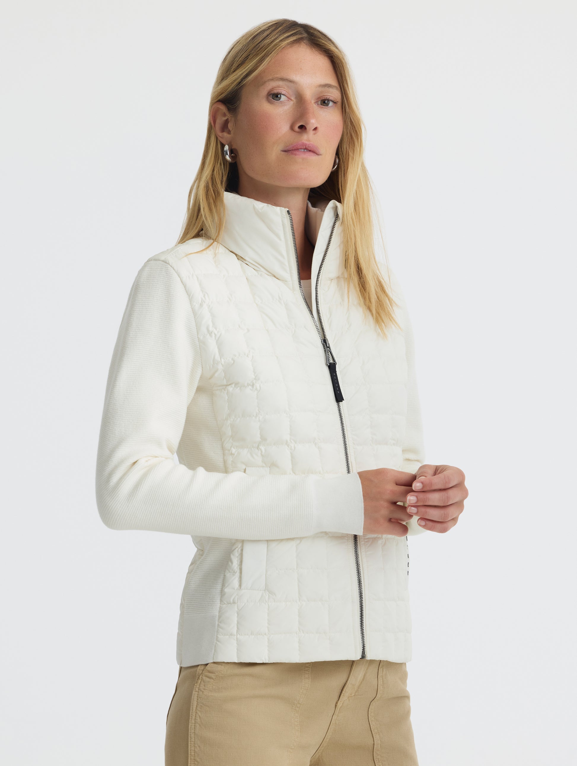 Front, angled, upper-body view of woman wearing Phase Full-Zip in Winter White from AETHER Apparel.