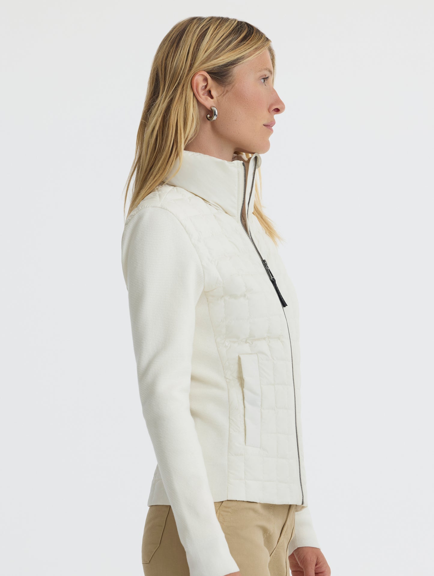 Side, profiel view of woman wearing Phase Full-Zip in Winter White from AETHER Apparel.