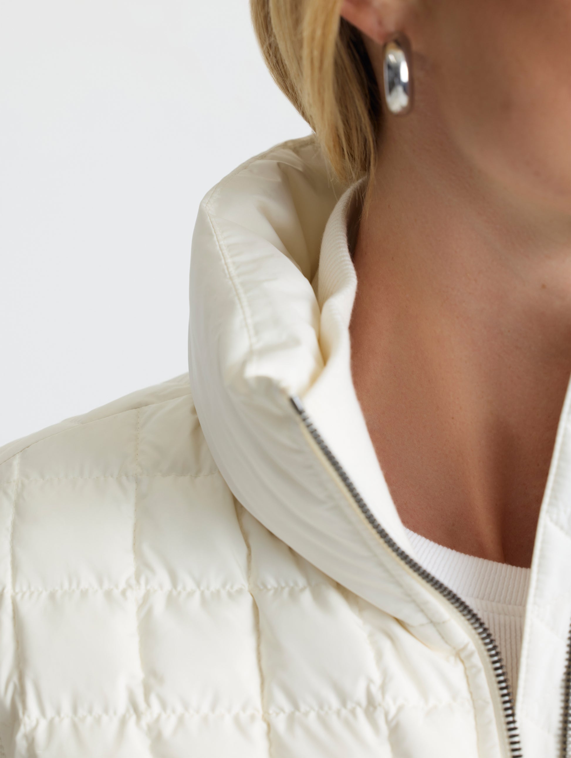 Closeup detailed view of the exterior insulated collar and cotton-and-cashmere blend interior collar on the Phase Full-Zip in Winter White from AETHER Apparel.