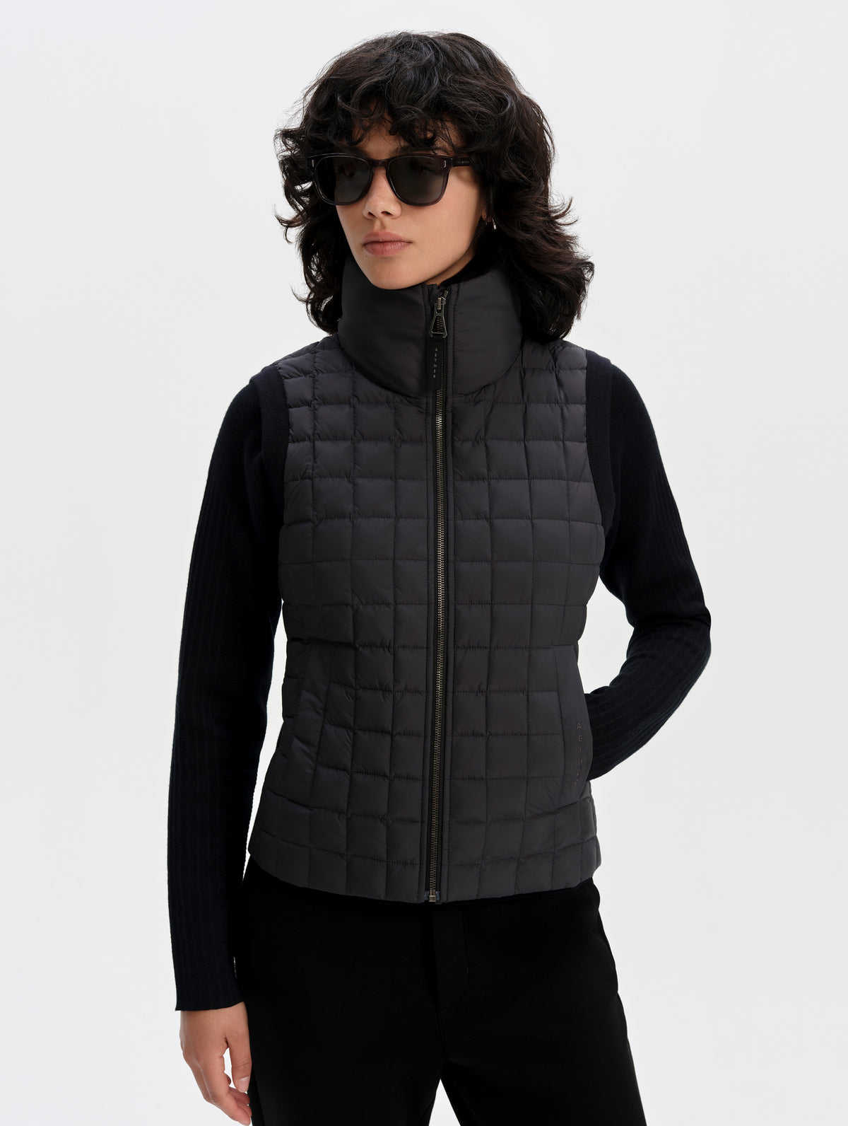 Front upper-body view of woman wearing the Phase Vest in Onyx Black from AETHER Apparel.