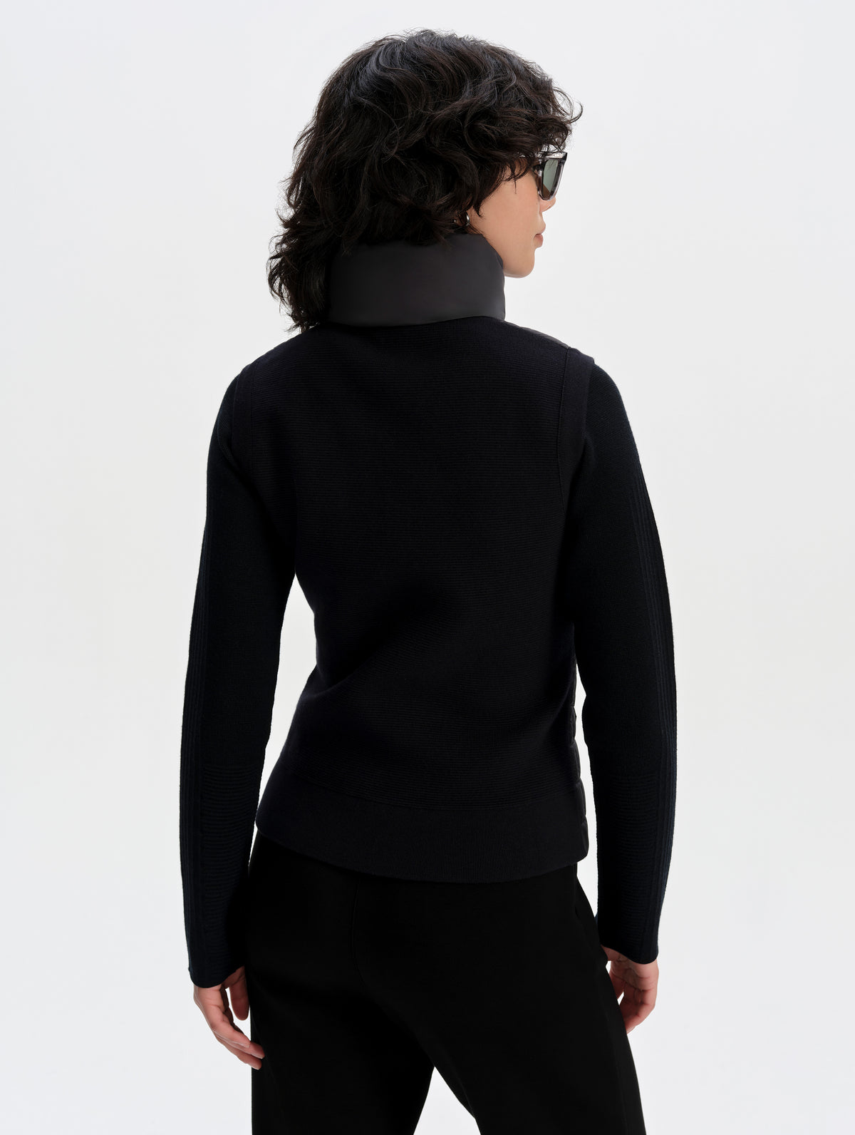Rear upper-body view of woman wearing the Phase Vest in Onyx Black from AETHER Apparel.