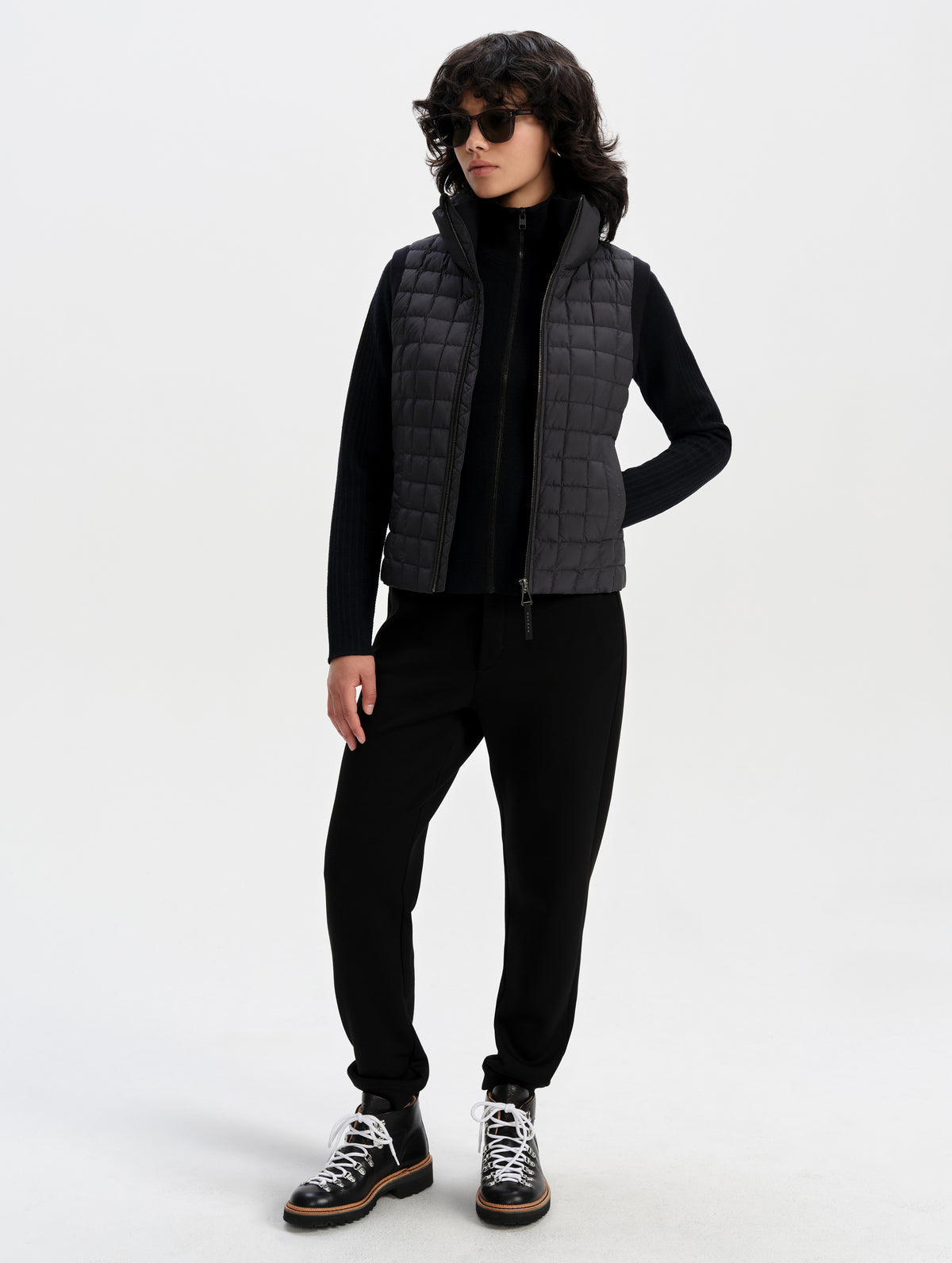 Front full-body view of woman wearing the Phase Vest in Onyx Black from AETHER Apparel.