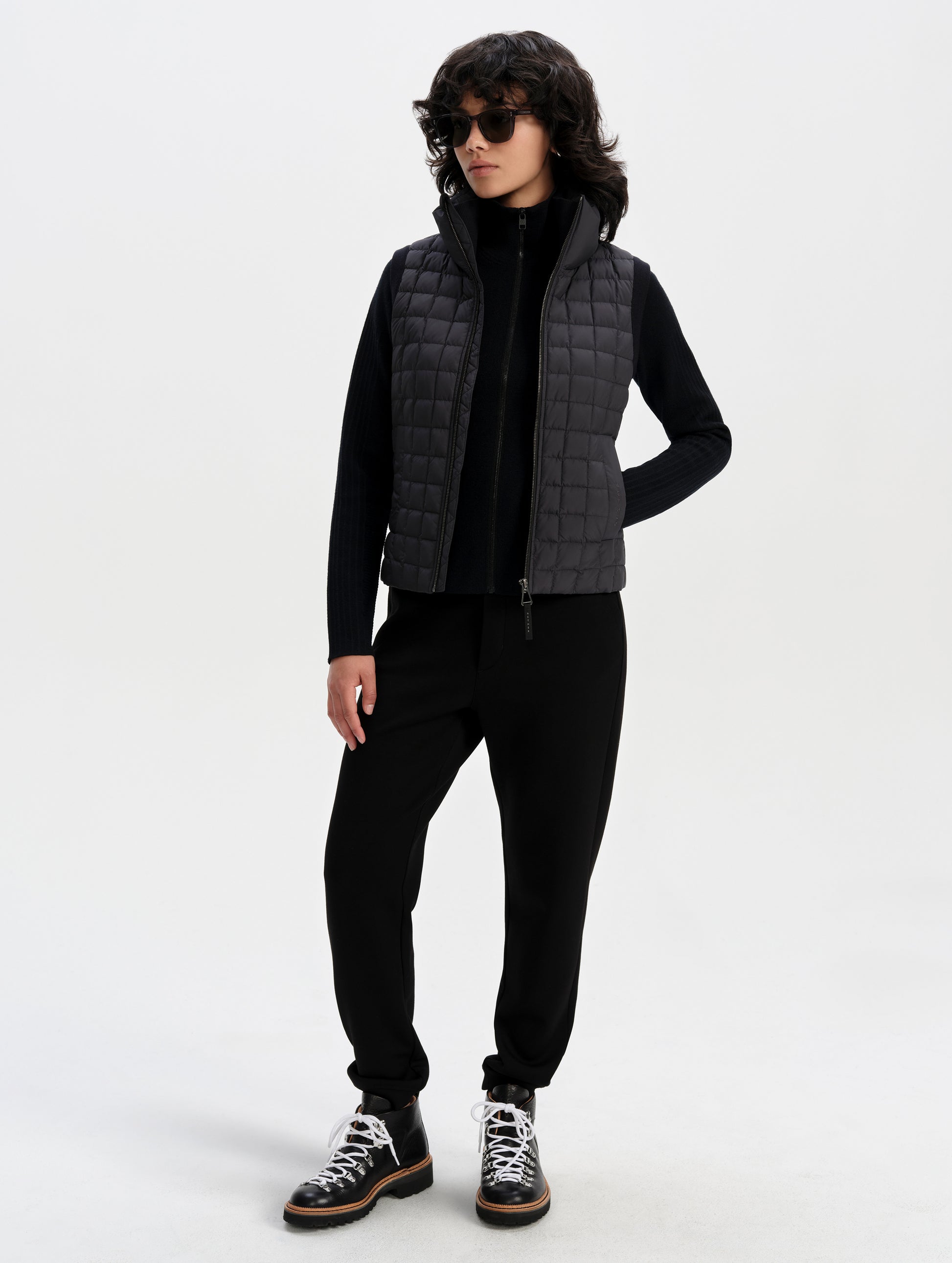 Front full-body view of woman wearing the Phase Vest in Onyx Black from AETHER Apparel.