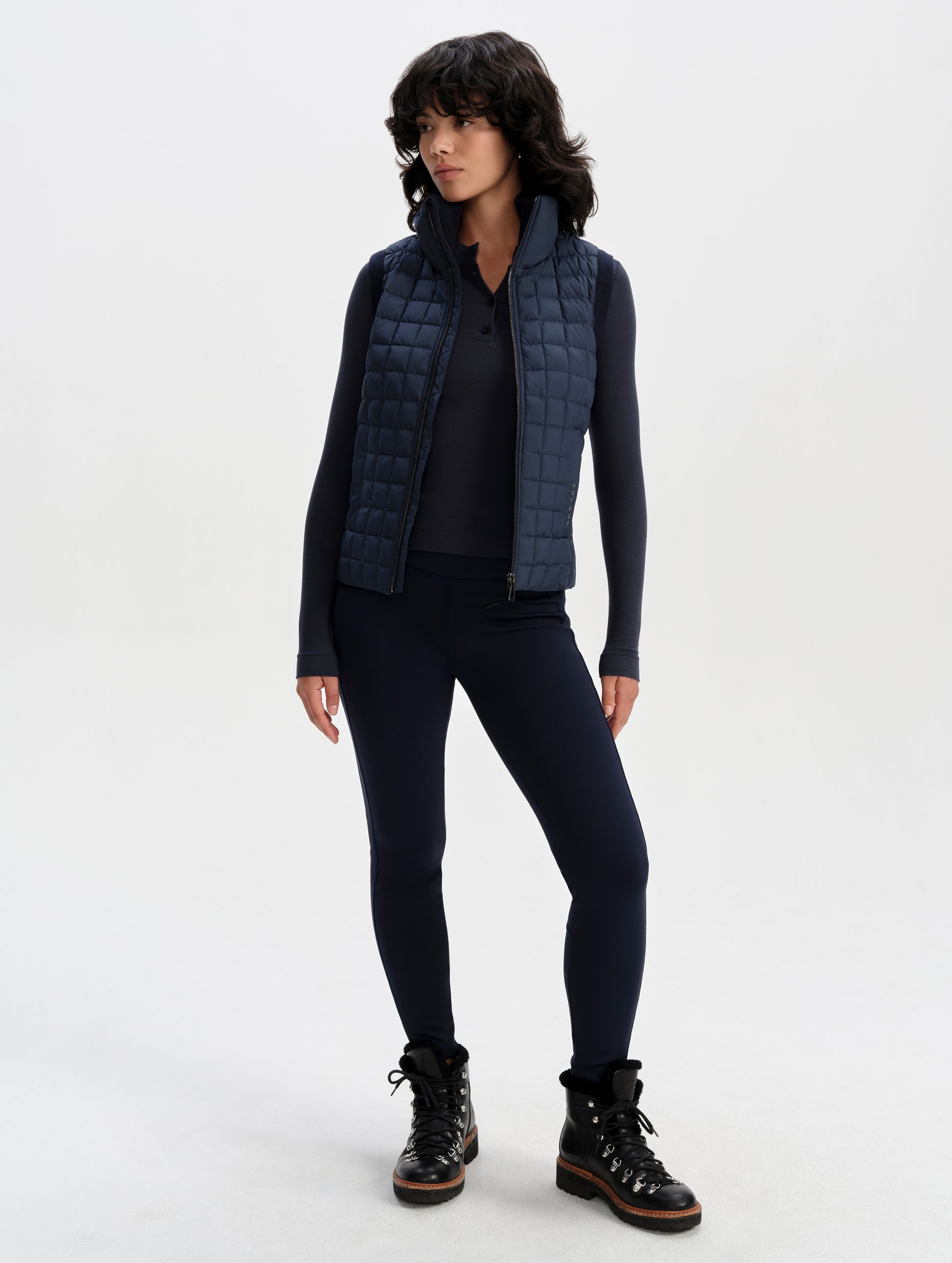 Front full-body view of woman wearing the Phase Vest in Total Eclipse from AETHER Apparel.