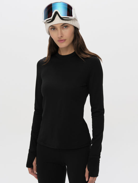 Front upper-body view of woman wearing Polar Base Layer Crew in Onyx Black from AETHER Apparel.