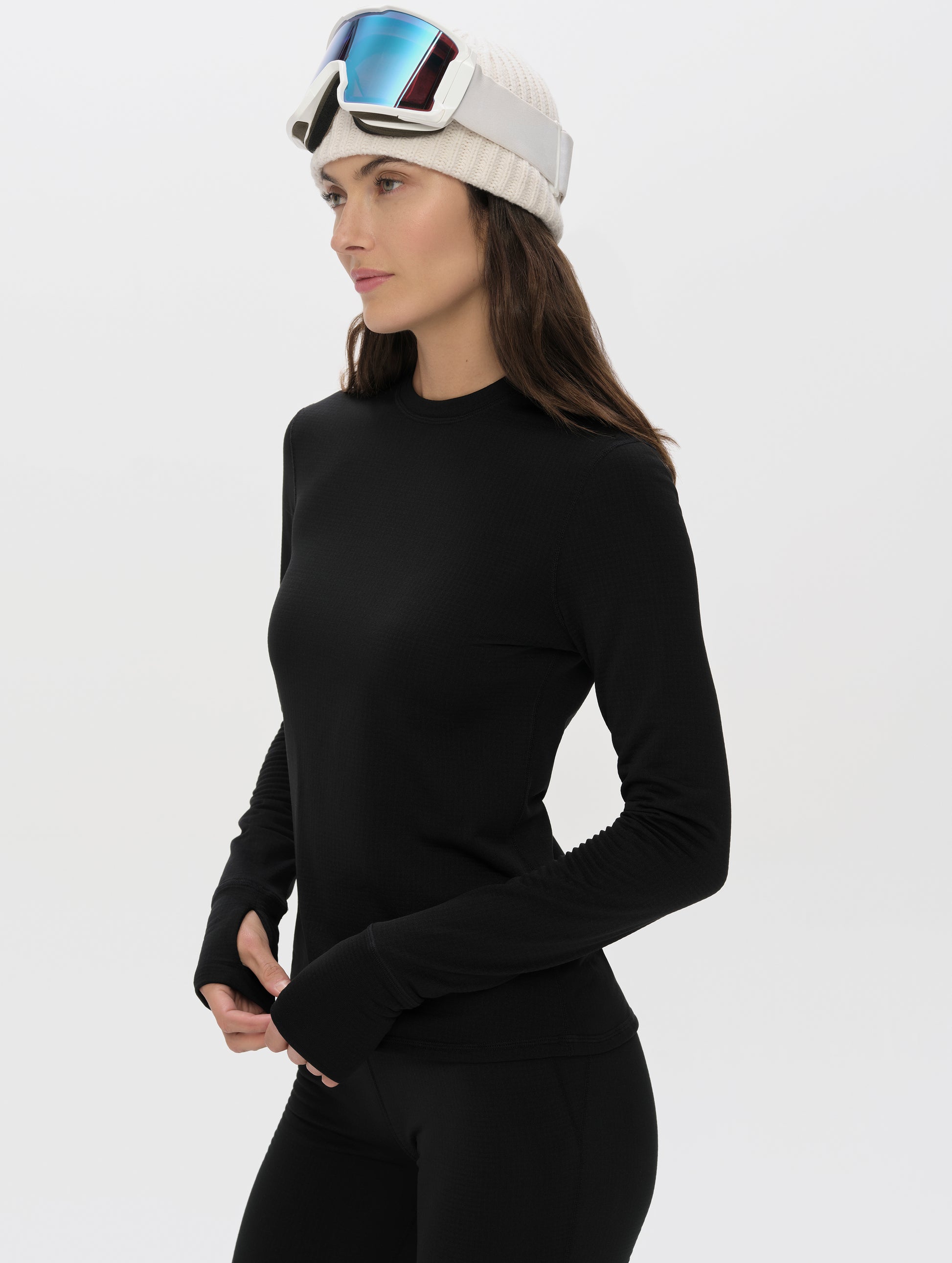 Front angled upper-body view of woman wearing Polar Base Layer Crew in Onyx Black from AETHER Apparel.