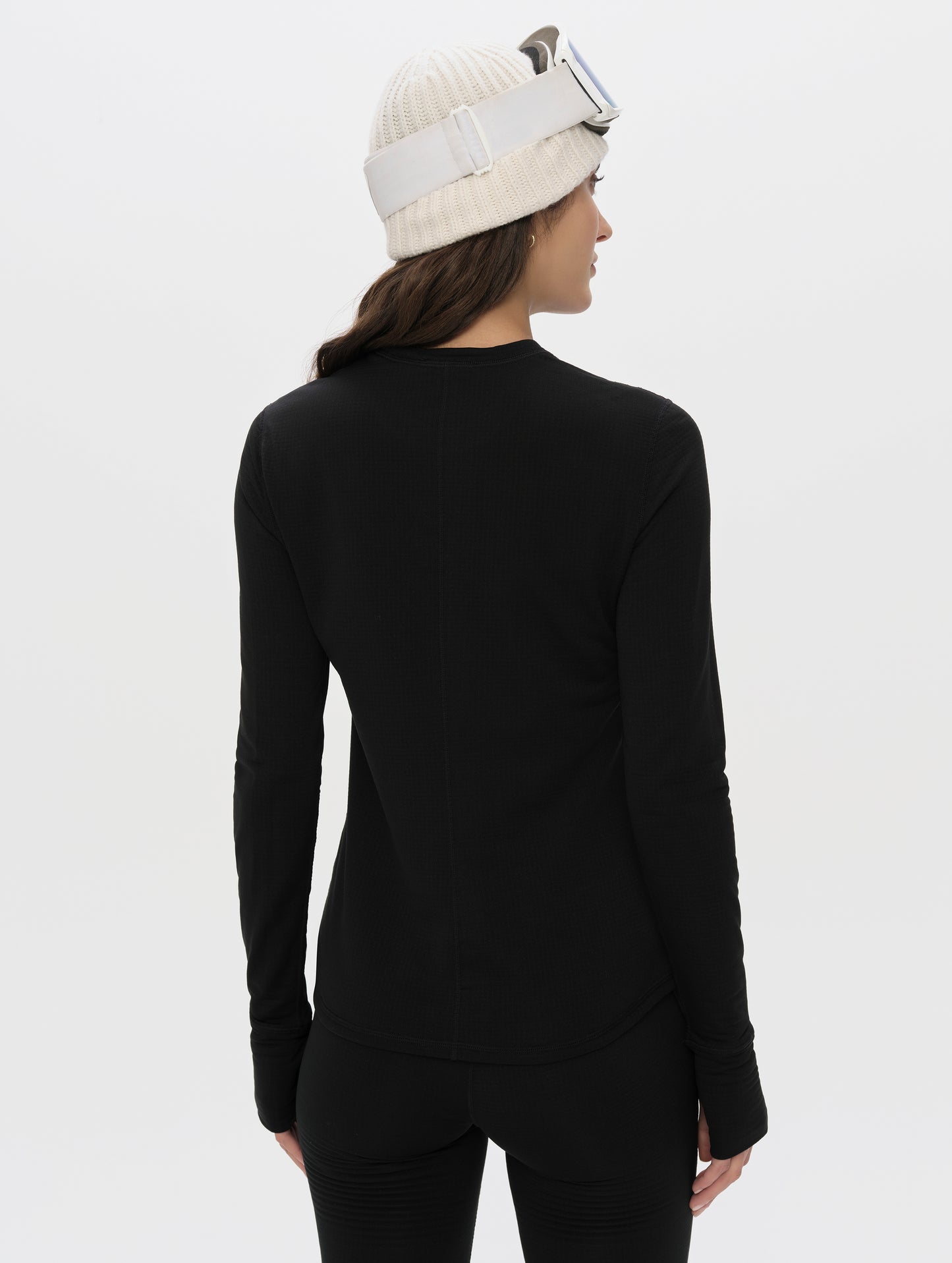 Rear upper-body view of woman wearing Polar Base Layer Crew in Onyx Black from AETHER Apparel.