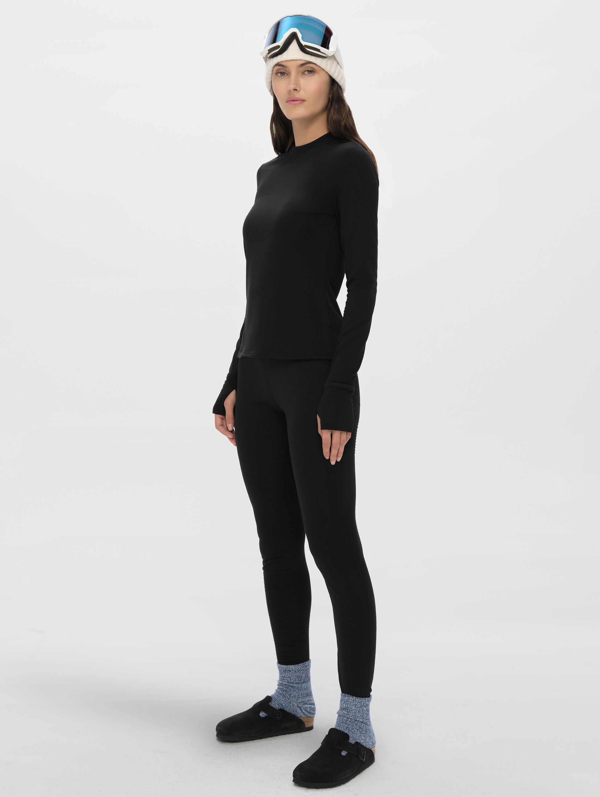 Front angled full-body view of woman wearing Polar Base Layer Crew in Onyx Black from AETHER Apparel.