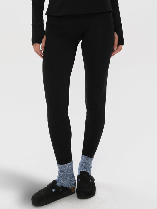 Front lower-body view of woman wearing Polar Base Layer Pant in Onyx Black from AETHER Apparel.