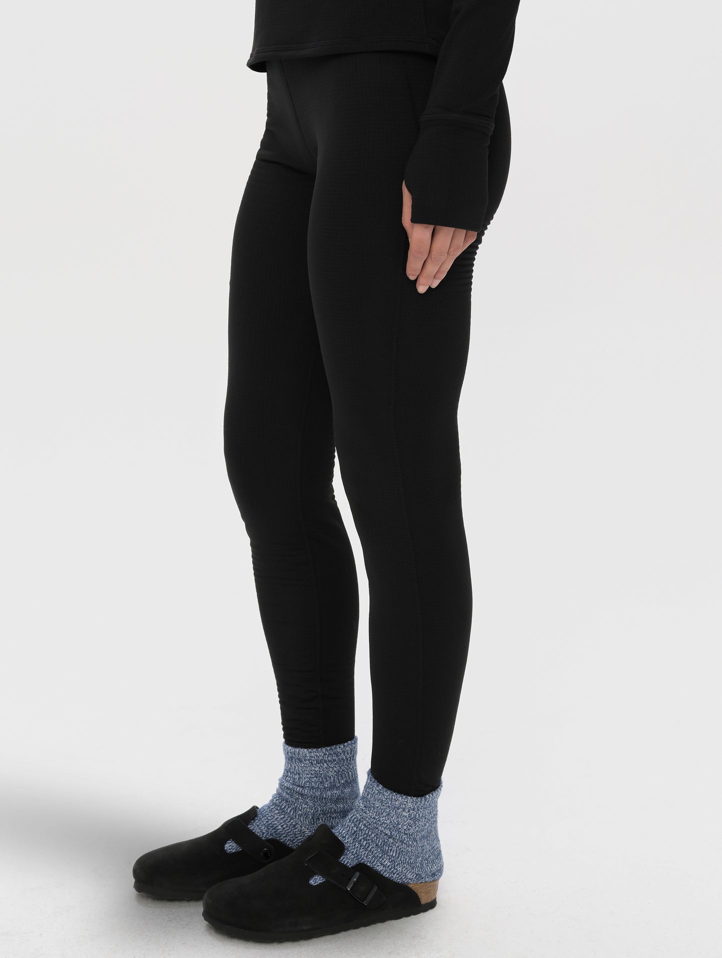 Front angled lower-body view of woman wearing Polar Base Layer Pant in Onyx Black from AETHER Apparel.