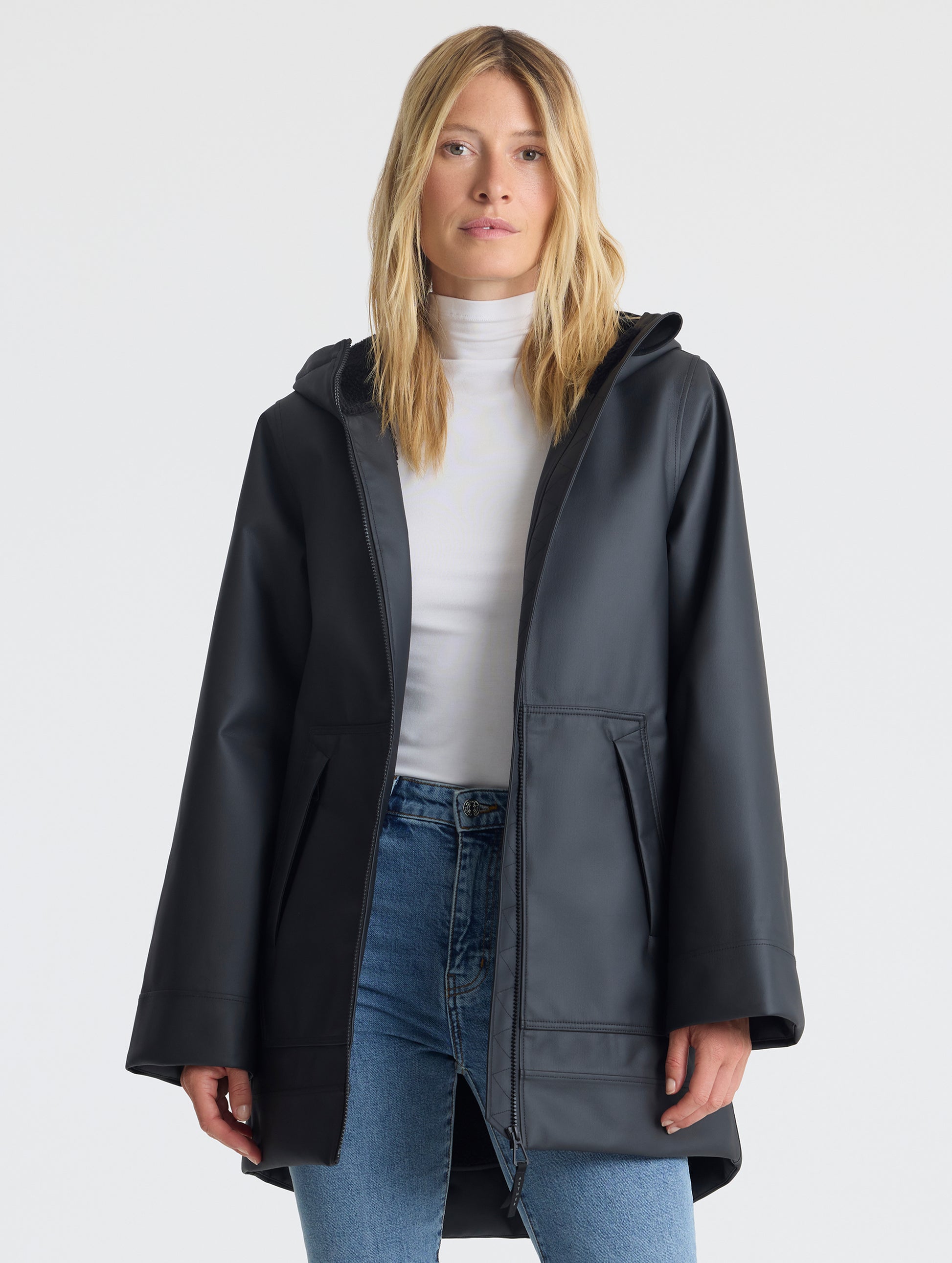 Front upper-body view of woman wearing the Quest Sherpa-Lined Rain Jacket Onyx Black from AETHER Apparel. 