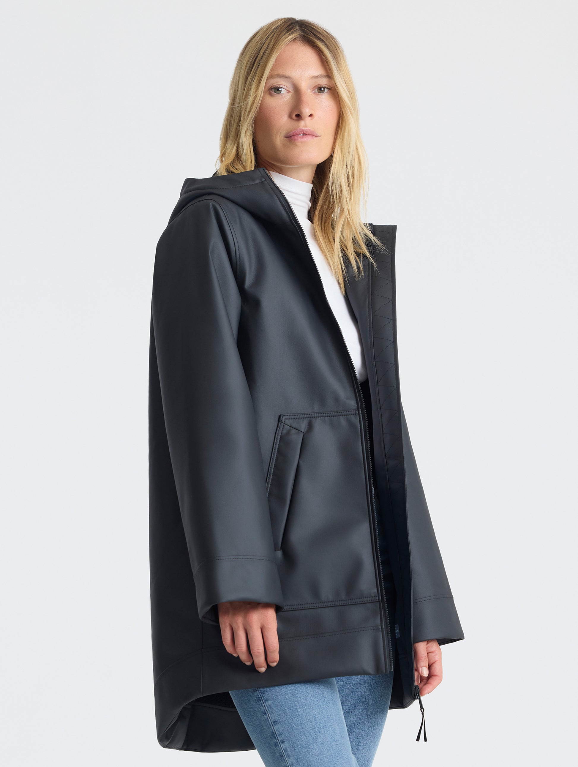 Front angled upper-body view of woman wearing the Quest Sherpa-Lined Rain Jacket Onyx Black from AETHER Apparel. 