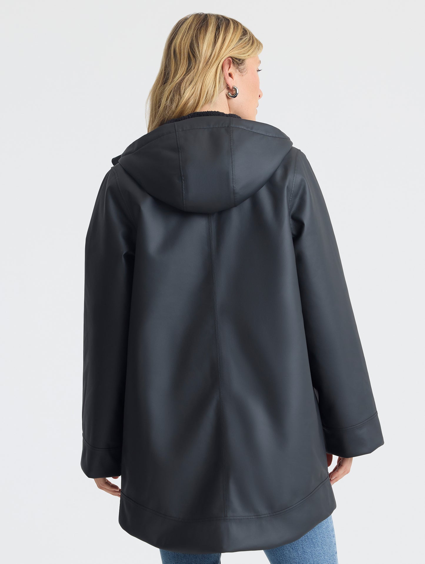 Rear upper-body view of woman wearing the Quest Sherpa-Lined Rain Jacket Onyx Black from AETHER Apparel. 