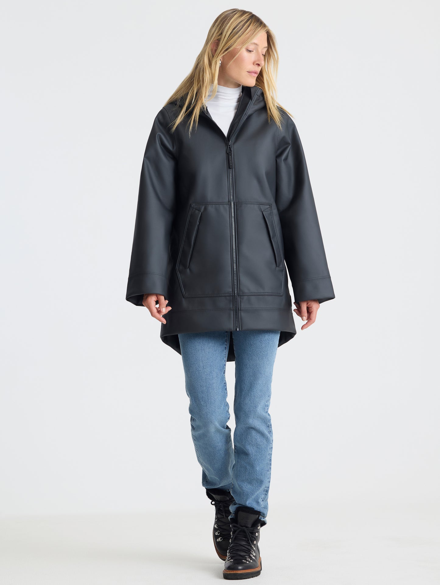 Front full-body view of woman wearing the Quest Sherpa-Lined Rain Jacket Onyx Black from AETHER Apparel. 