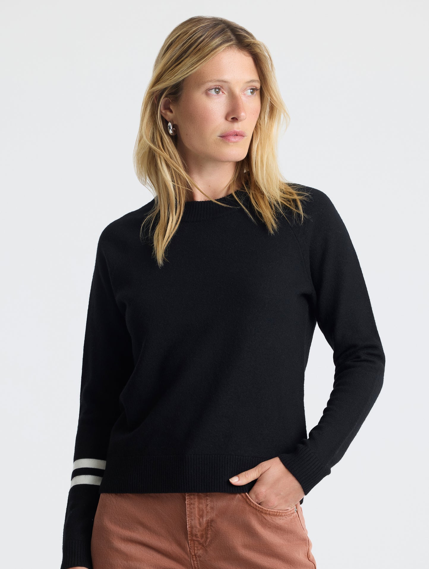 Upper body view of woman wearing Racer Sweater 2.0 in Onyx Black from AETHER Apparel.