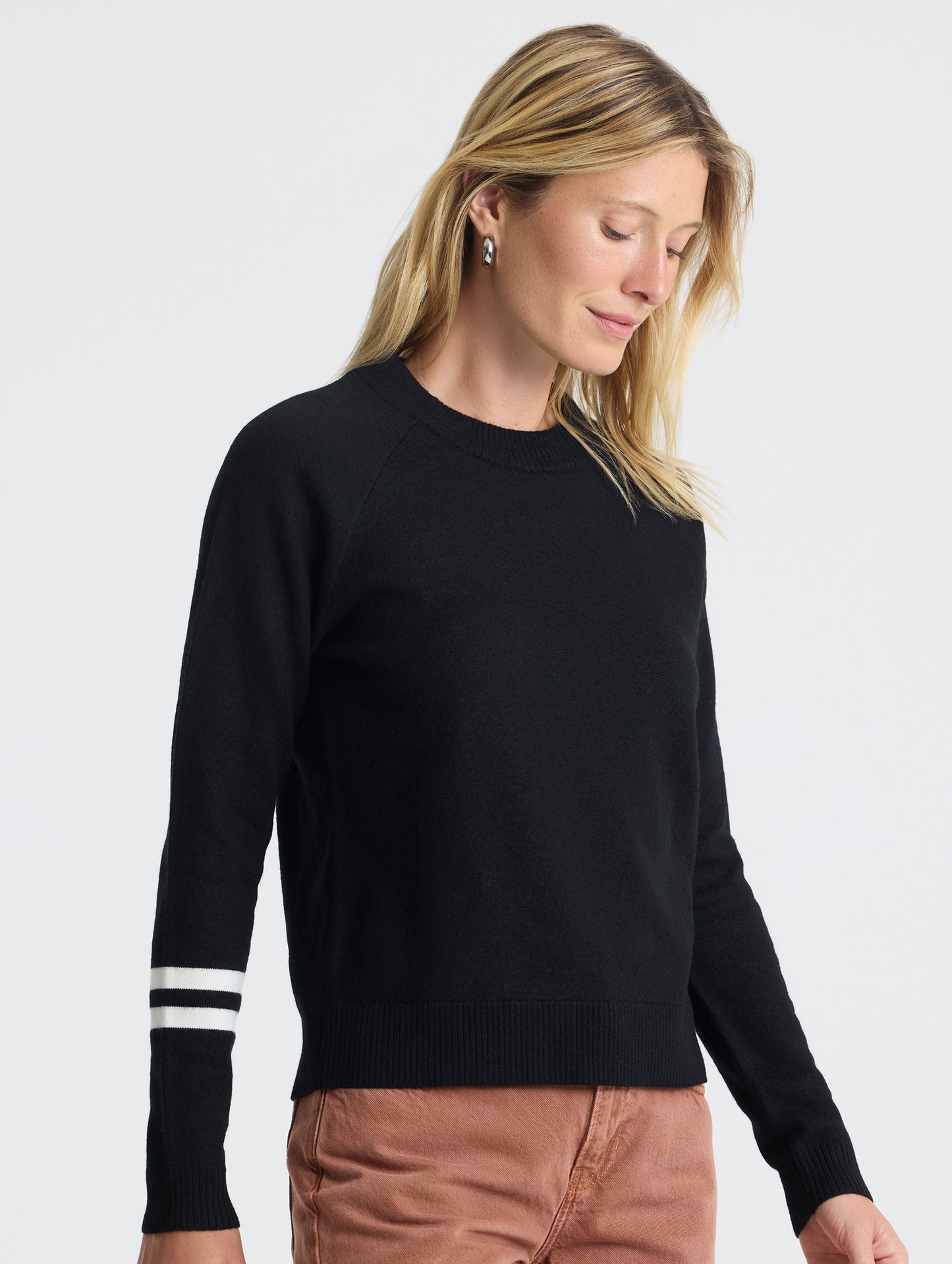 Closeup 3/4 view of woman wearing Racer Sweater 2.0 in Onyx Black from AETHER Apparel.