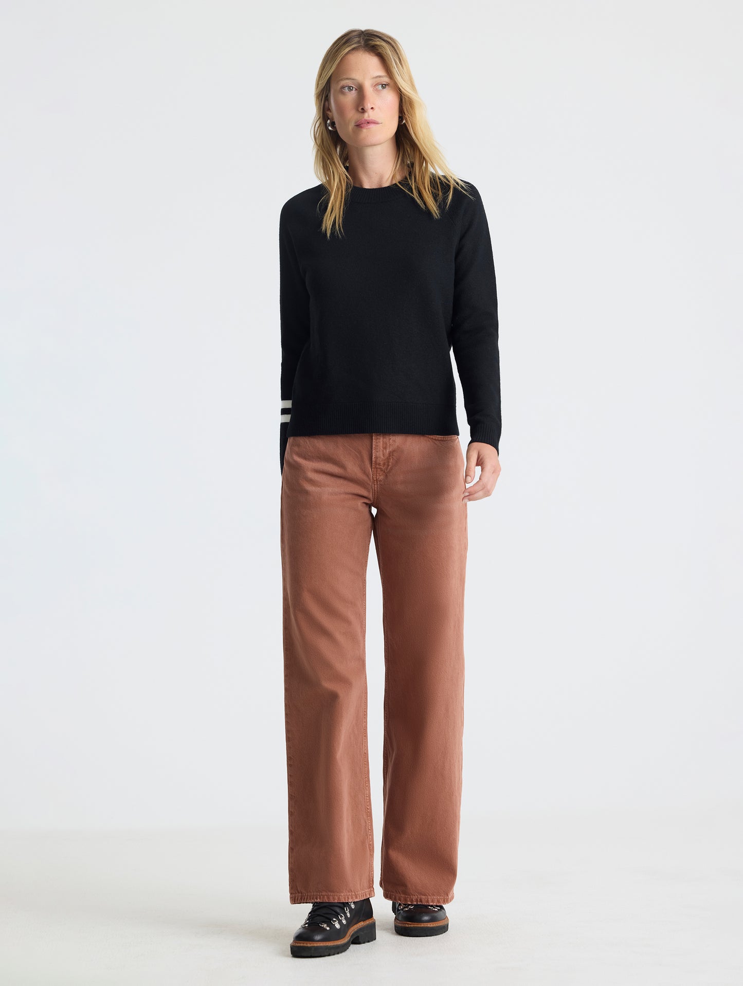 Full body view of woman wearing Racer Sweater 2.0 in Onyx Black from AETHER Apparel.