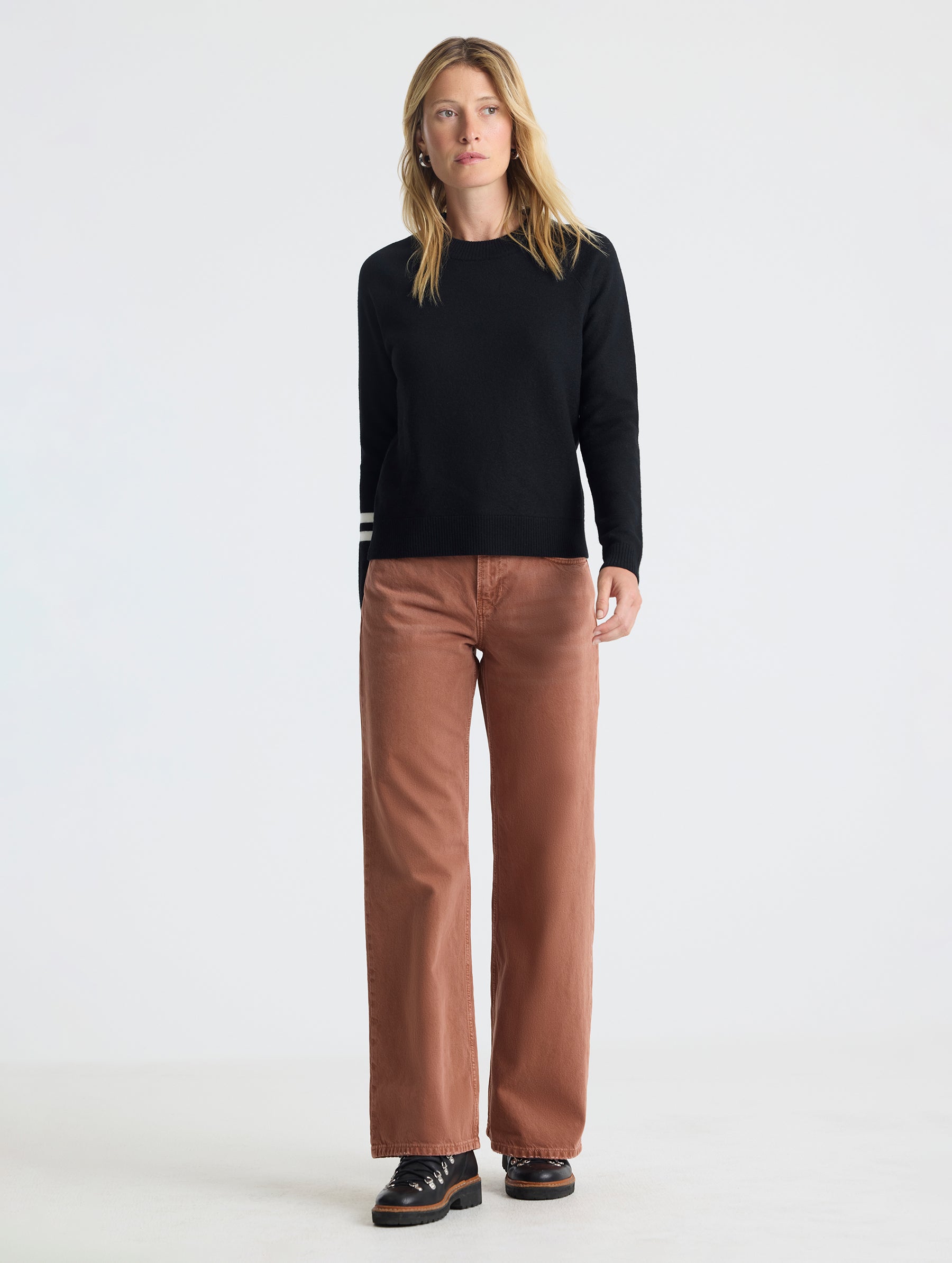 Full body view of woman wearing Racer Sweater 2.0 in Onyx Black from AETHER Apparel.