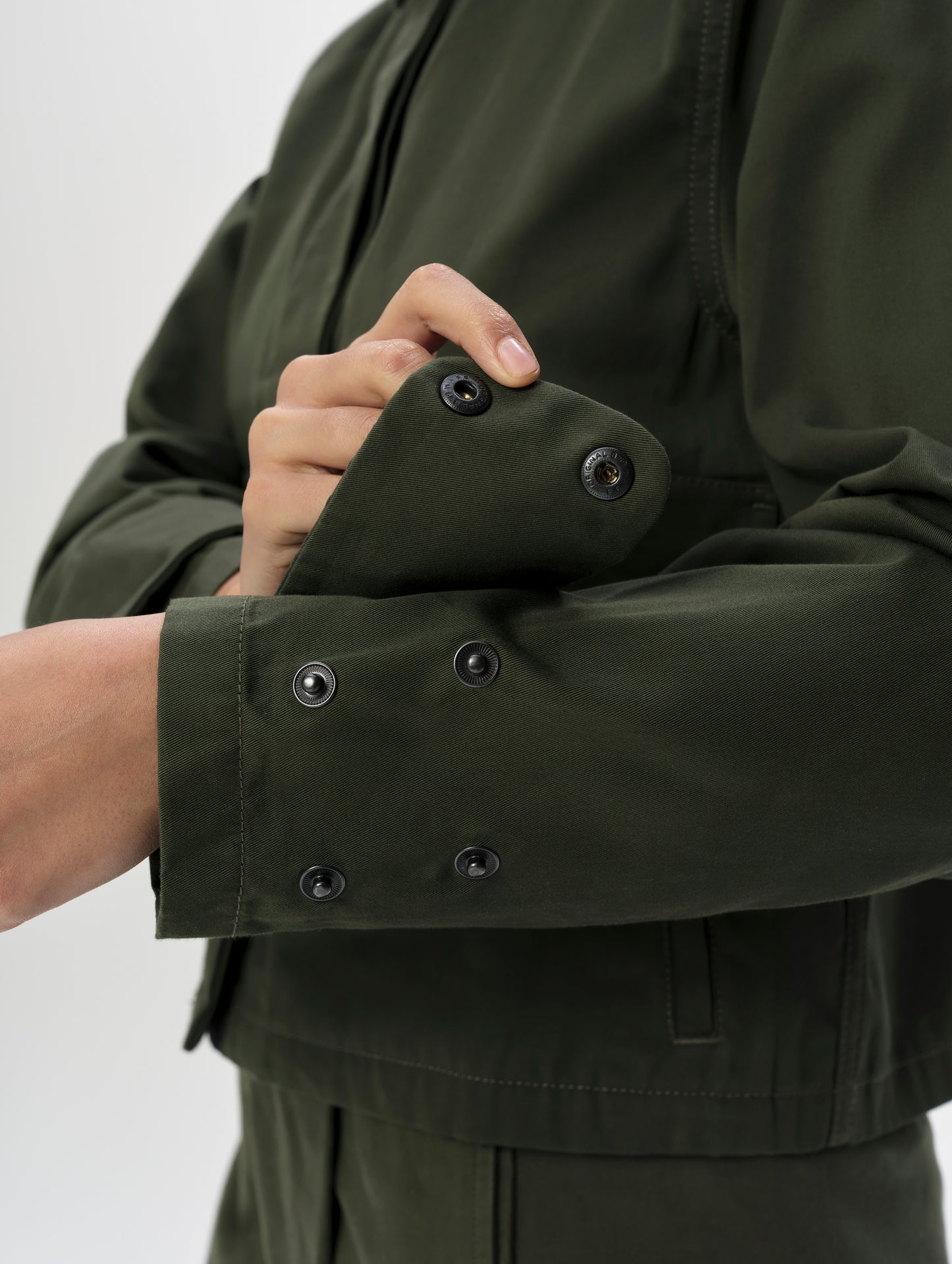 Closeup detailed view of quad snap cuffs on the Raven Waxed Cotton Jacket in Forest Green from AETHER Apparel.