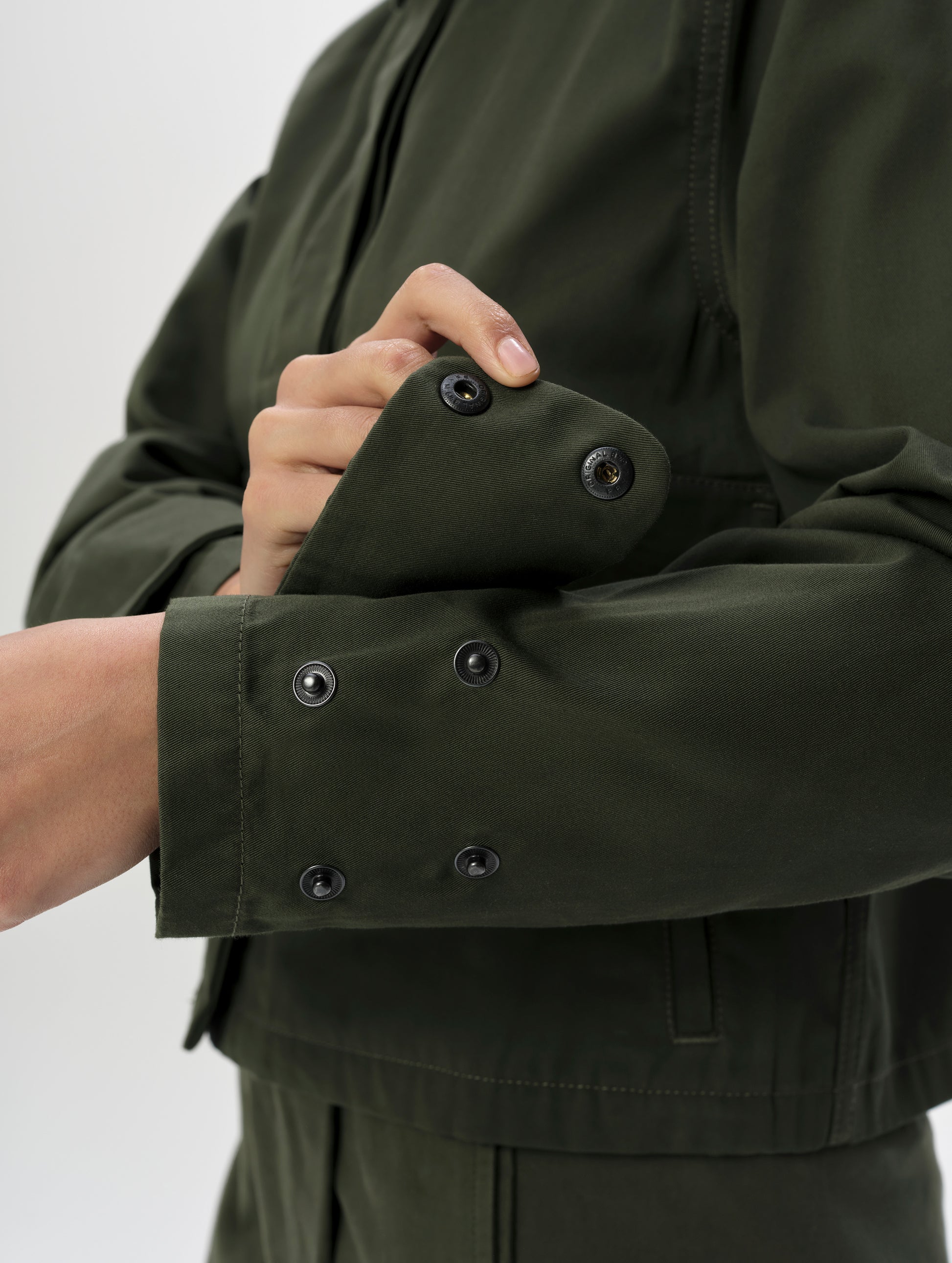Closeup detailed view of quad snap cuffs on the Raven Waxed Cotton Jacket in Forest Green from AETHER Apparel.