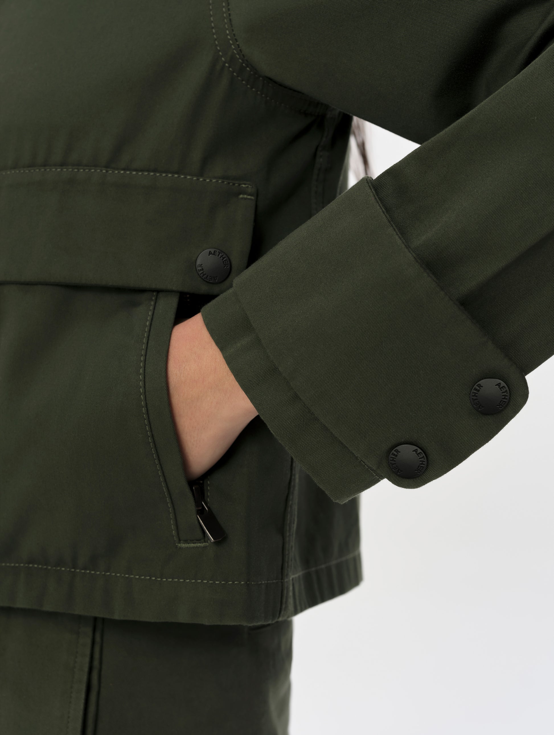 Closeup detailed view of quad snap cuffs and hand pockets on the Raven Waxed Cotton Jacket in Forest Green from AETHER Apparel.