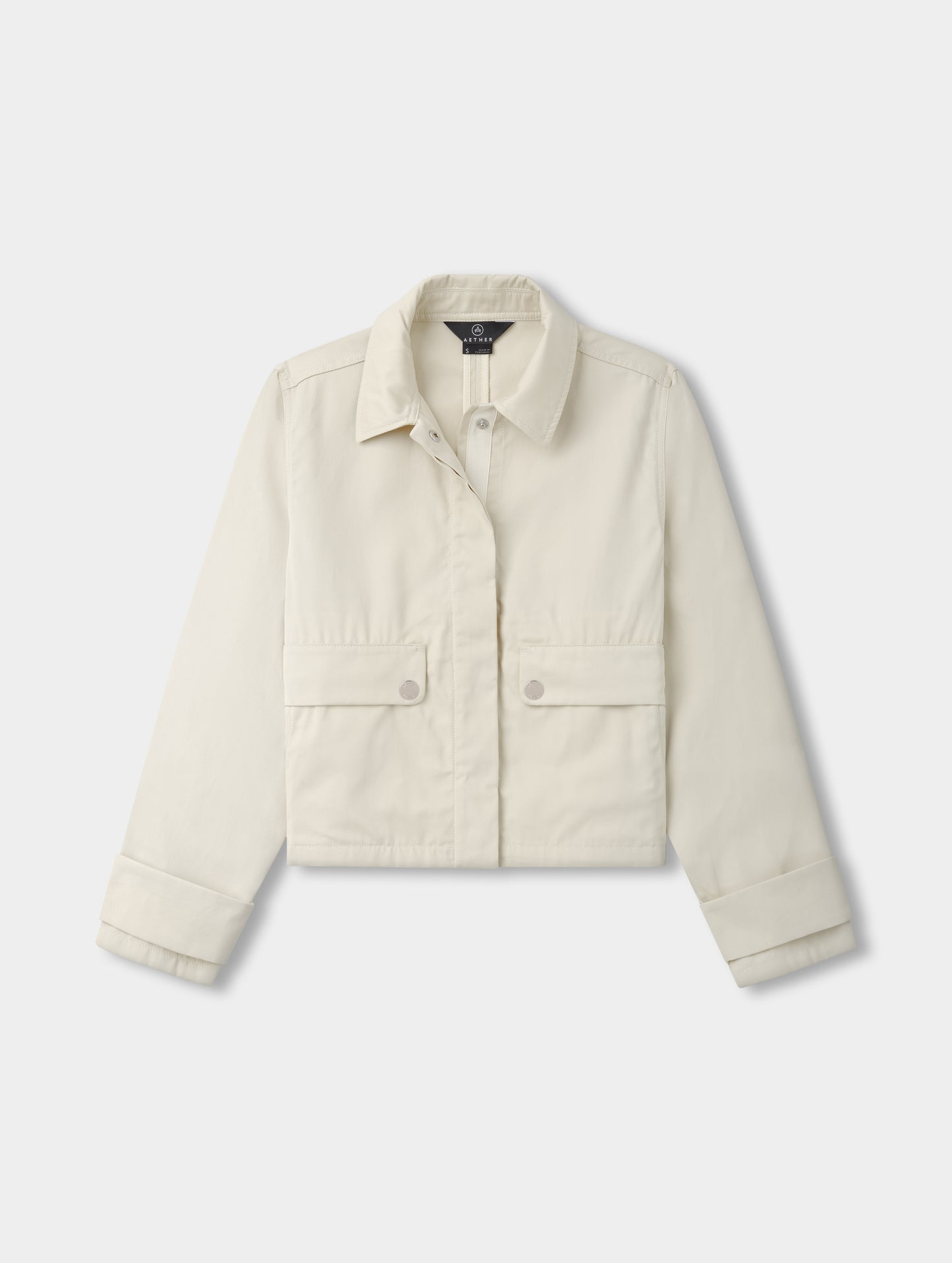 Flat lay view of the Raven Waxed Cotton Jacket in Bone from AETHER.