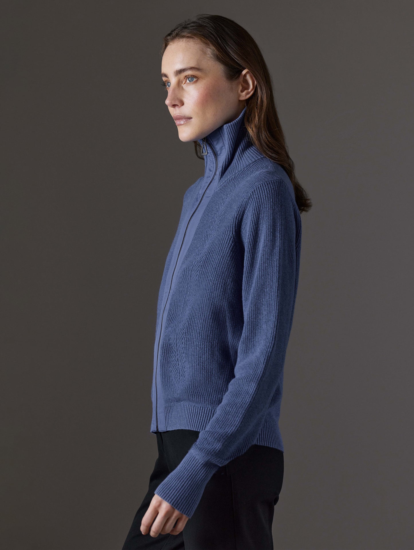 Side profile view of woman wearing Rhea Full-Zip Sweater in Portal Blue Heather from AETHER Apparel.