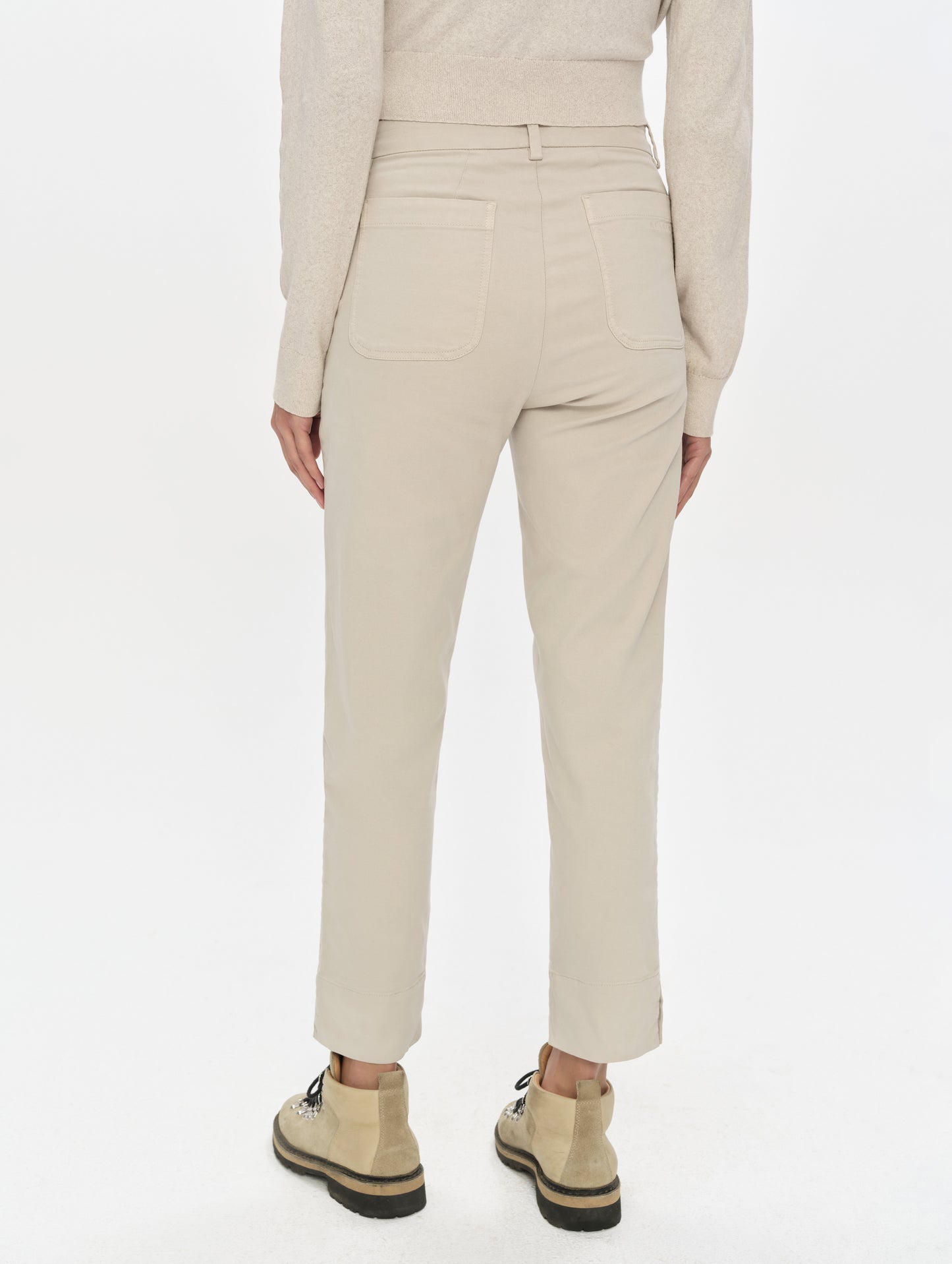 Rear, lower-body view of woman wearing the Rhy Straight Leg Pant in Bone from AETHER Apparel.
